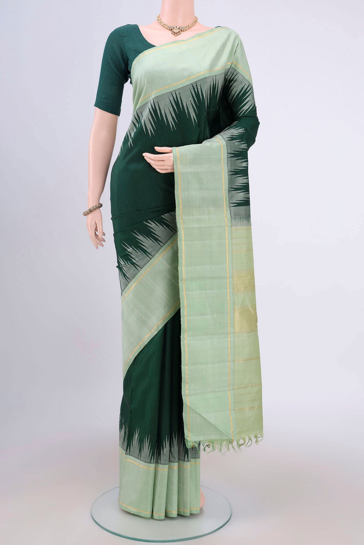 Bottle Green Kanjivaram Silk Saree with Plain Body and Temple Border.  displayed on a mannequin