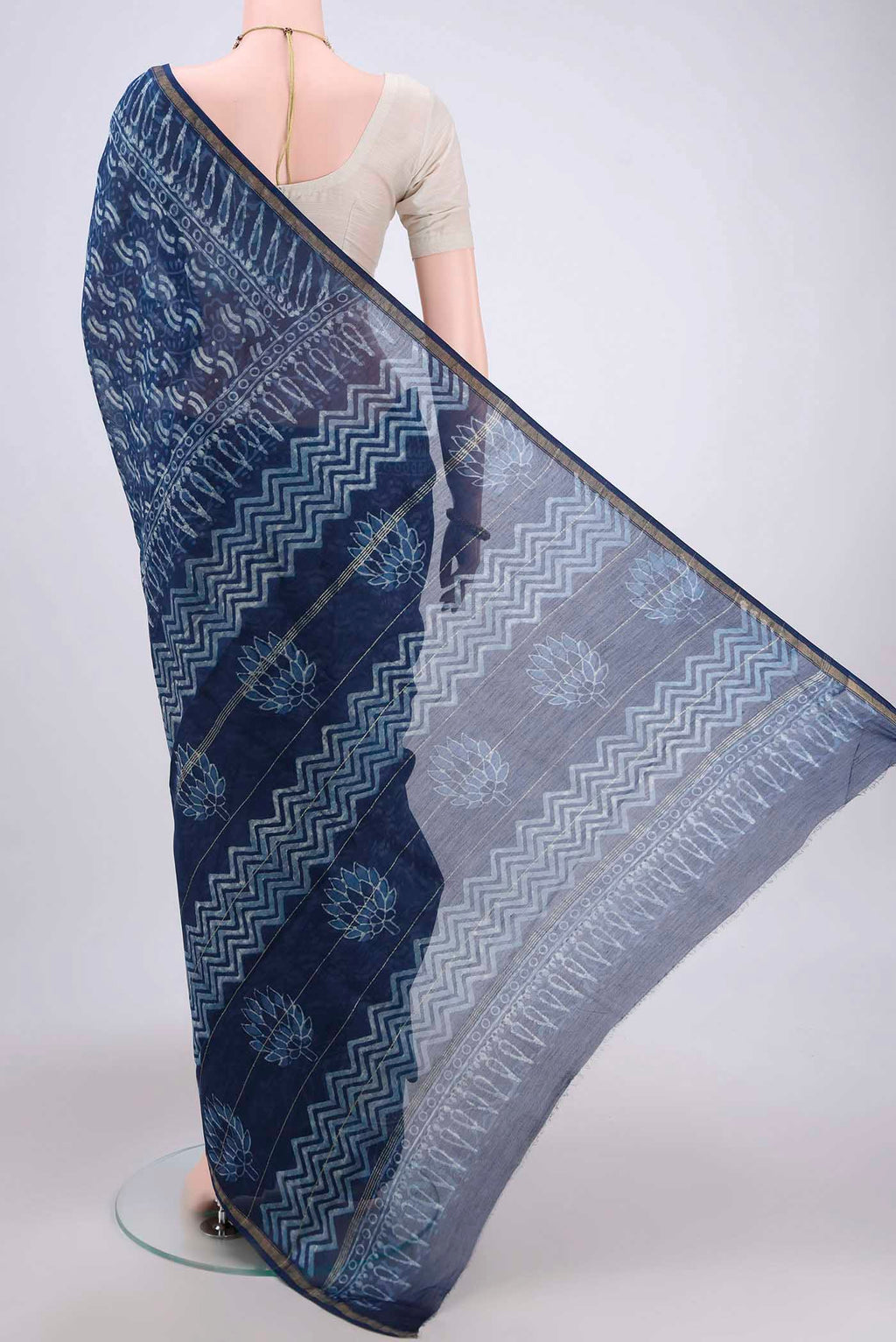 Flat view of Indigo Maheshwari Silk Cotton Saree with Printed design on the body and Thin Zari Line. 