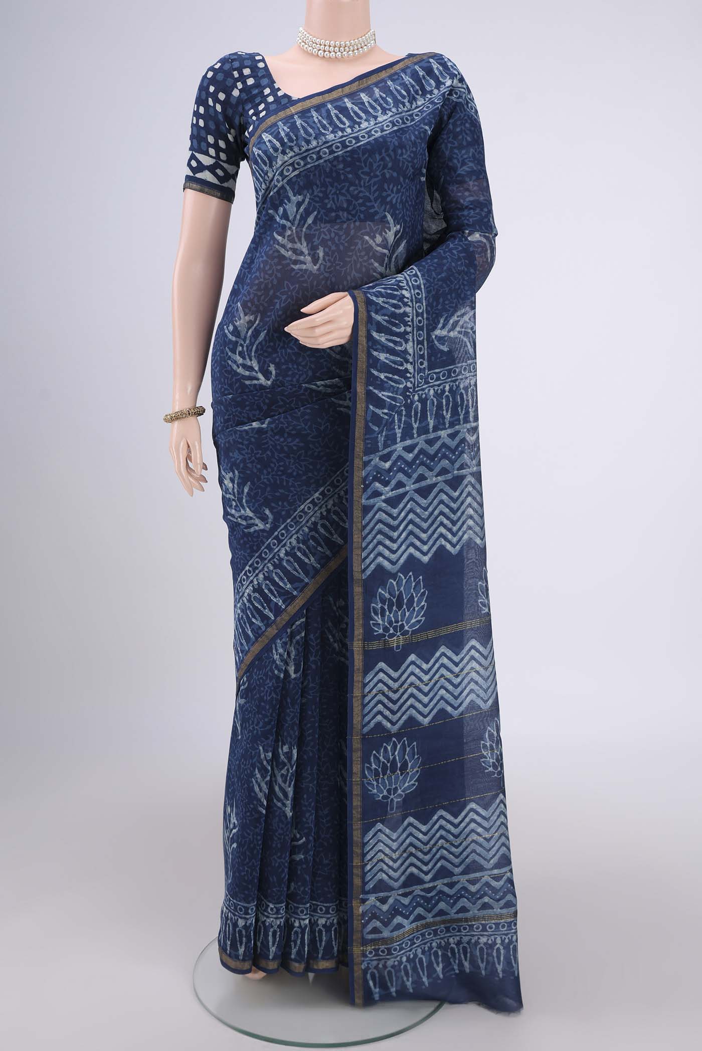 Indigo Maheshwari Silk Cotton Saree with Batik Print on the body and Zari Border.  displayed on a mannequin