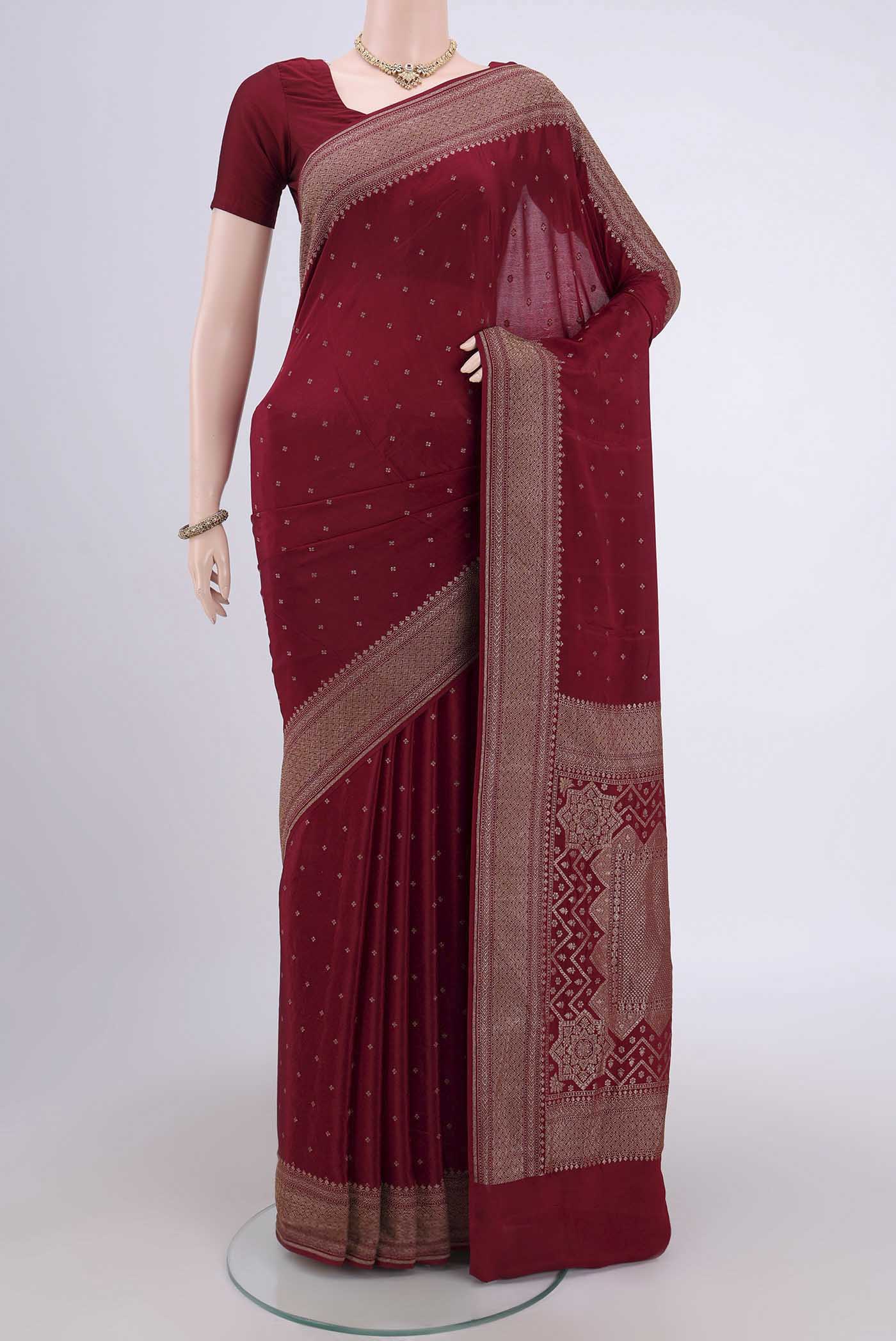 Maroon Banarasi Georgette Saree with Zari Butta on the body and Zari Border.  displayed on a mannequin