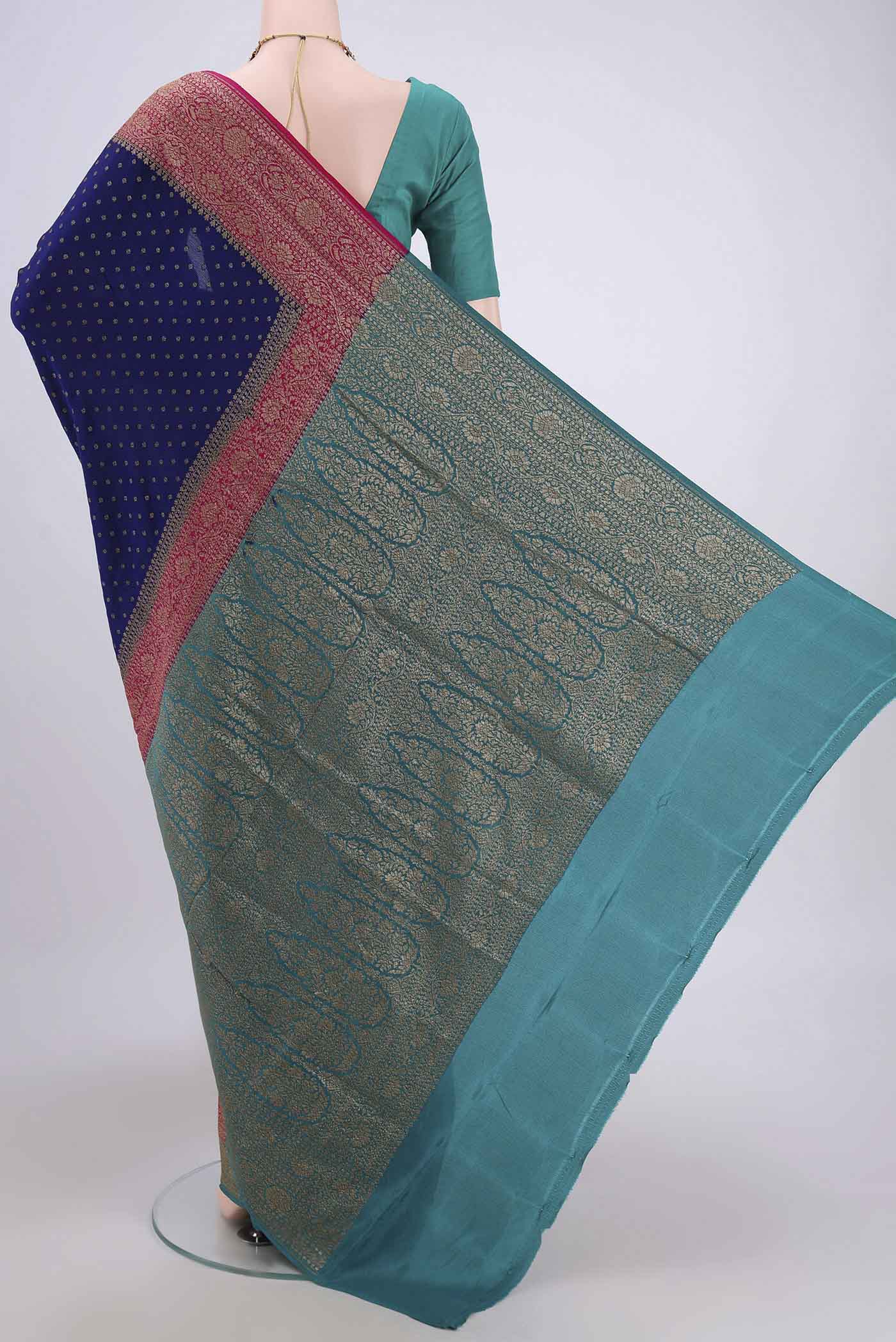 Flat view of Royal Blue Banarasi Georgette Saree with Zari Butta on the body and Zari Border. 