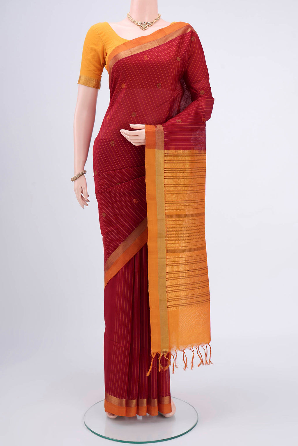 Maroon Coimbatore Silk Cotton Saree with Stripes on the body and Zari Border.  displayed on a mannequin