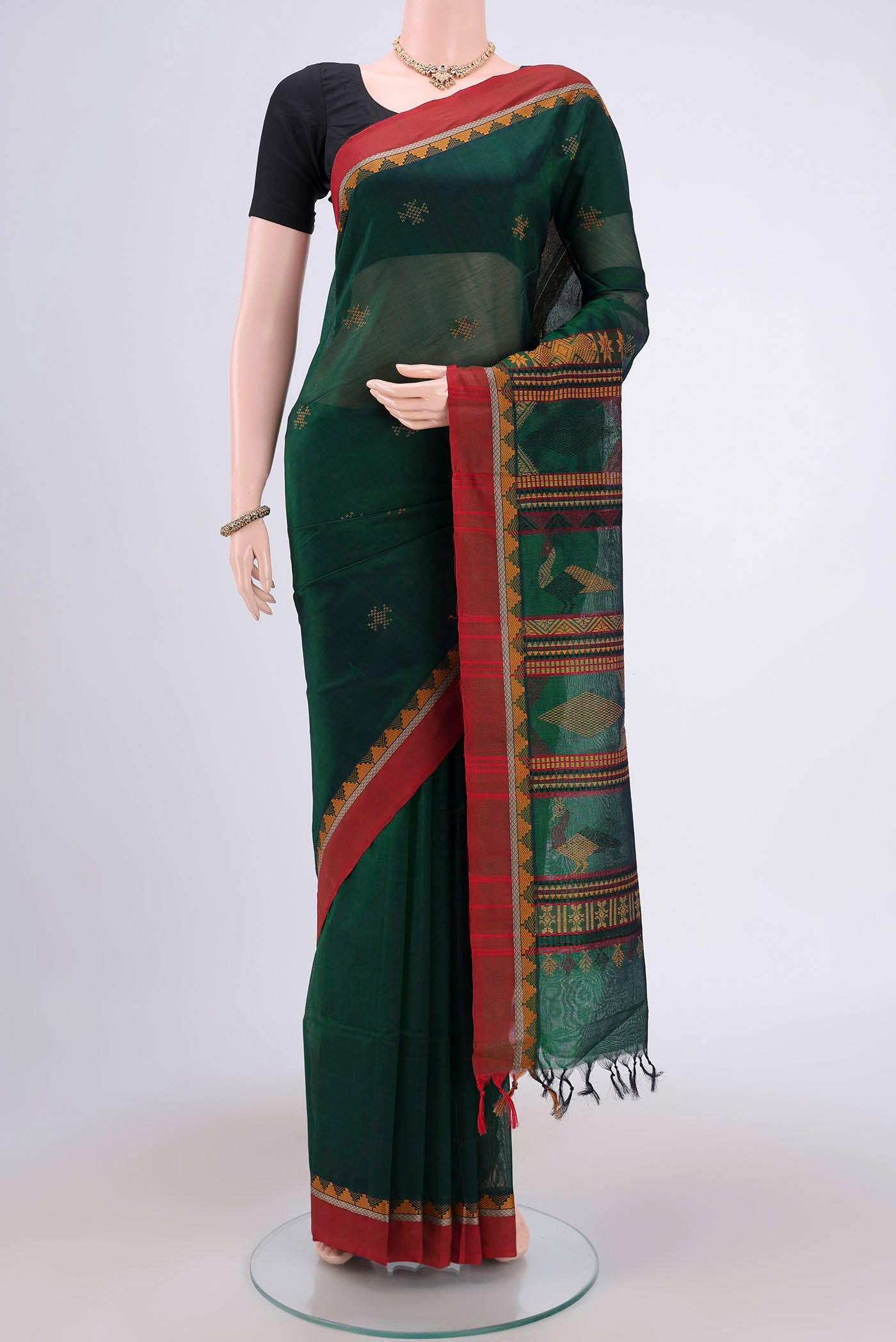 Bottle Green Coimbatore Silk Cotton Saree with Thread Butta on the body and Plain Border.  displayed on a mannequin