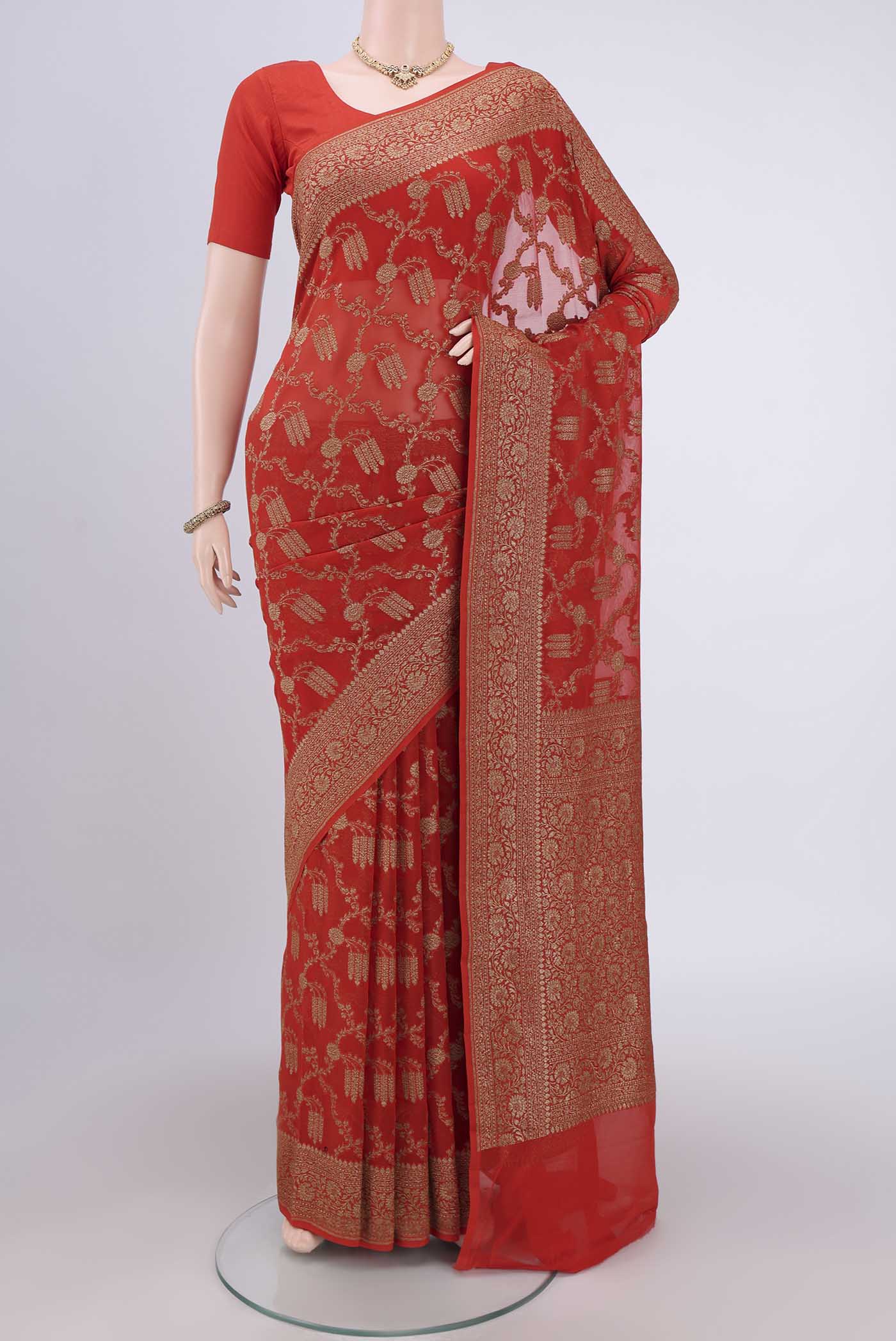 Brick Orange Banarasi Georgette Saree with Zari Brocade on the body and Zari Border.  displayed on a mannequin