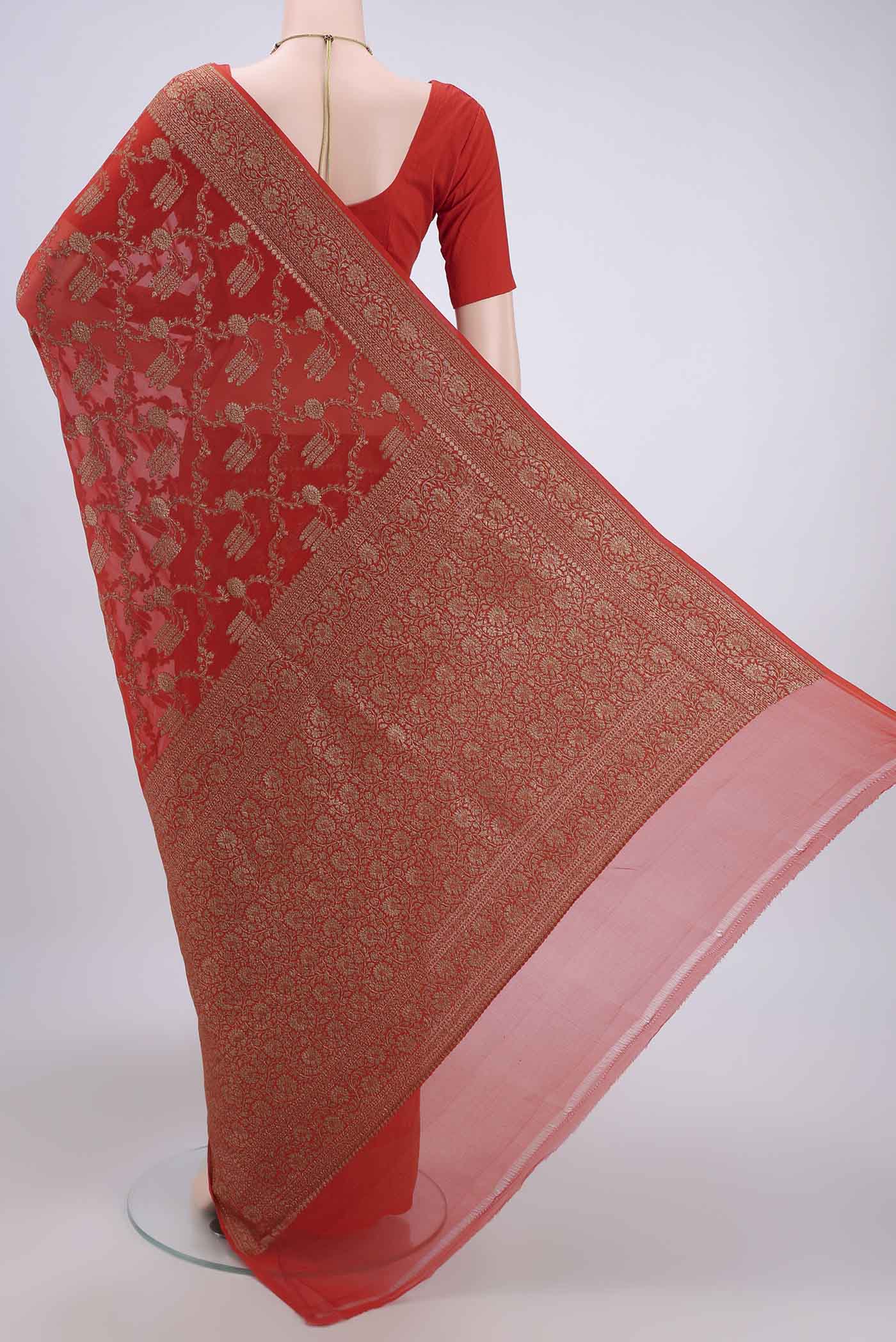 Flat view of Brick Orange Banarasi Georgette Saree with Zari Brocade on the body and Zari Border. 