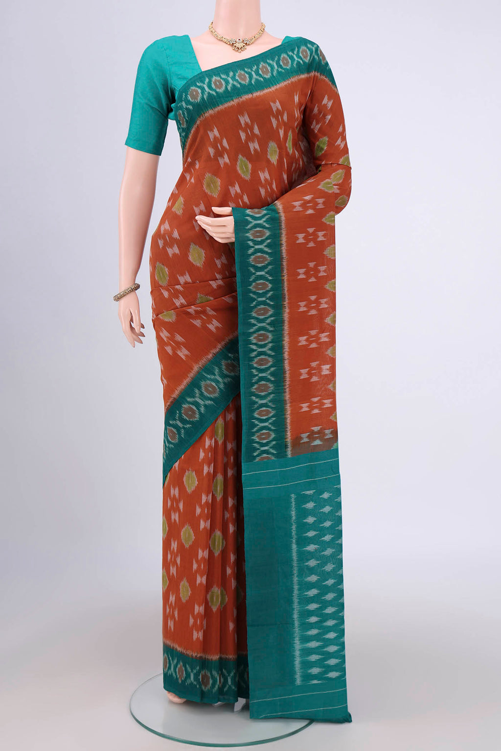 Rust Pochampally Cotton Saree with Ikat design on the body and Ikat Border.  displayed on a mannequin