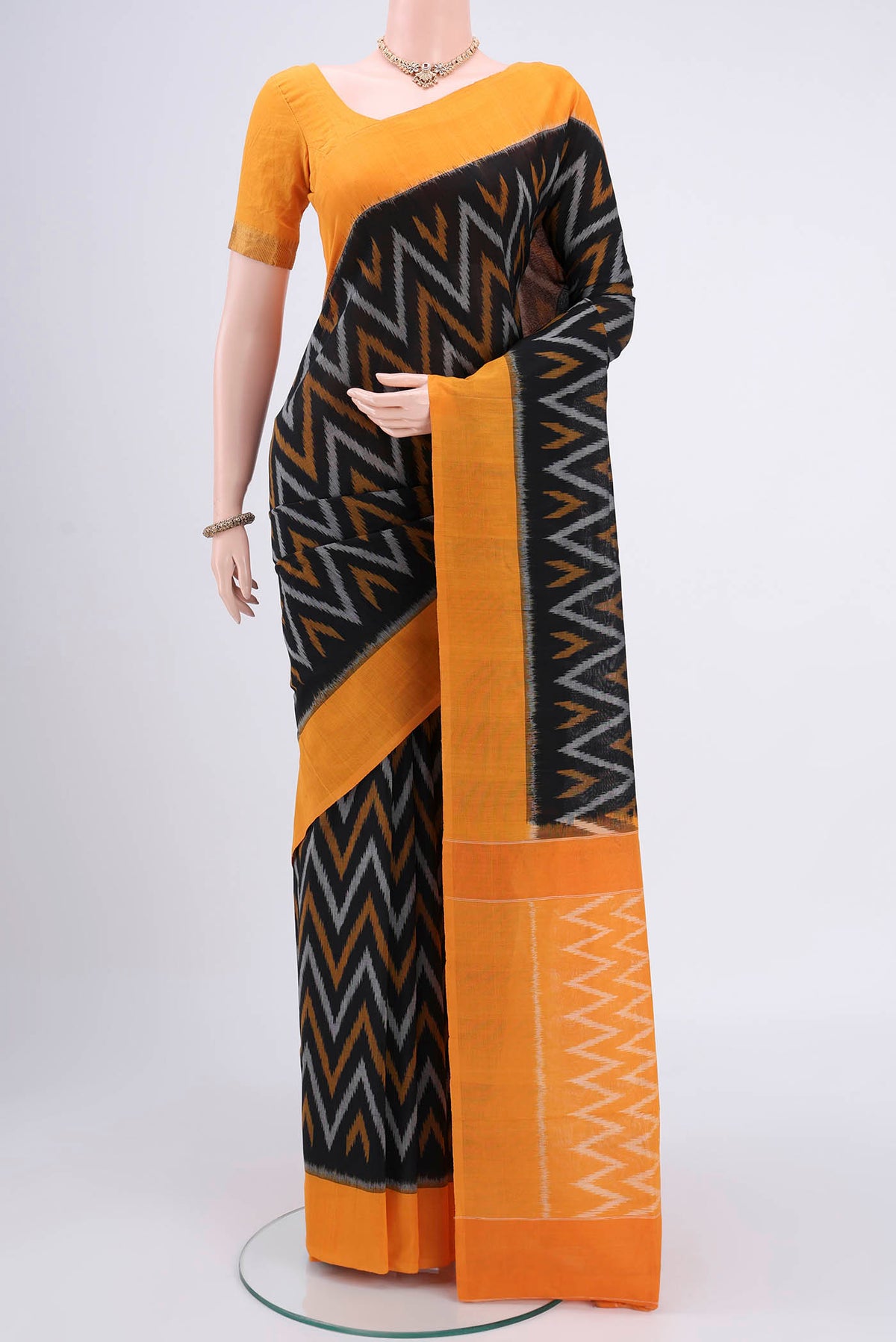 Black Pochampally Cotton Saree with Ikat design on the body and Ikat Border.  displayed on a mannequin