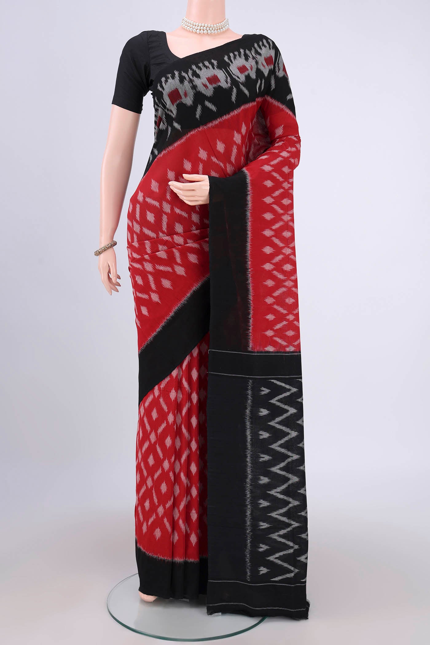 Red Pochampally Cotton Saree with Ikat design on the body and Ikat Border.  displayed on a mannequin