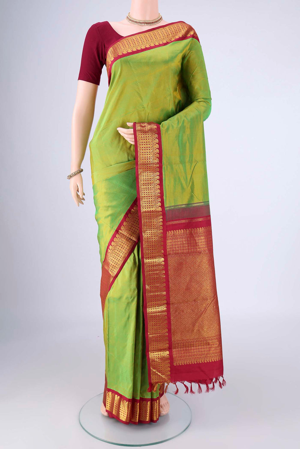 Light Green Kanjivaram Silk Saree with Plain Body and Zari Border.  displayed on a mannequin