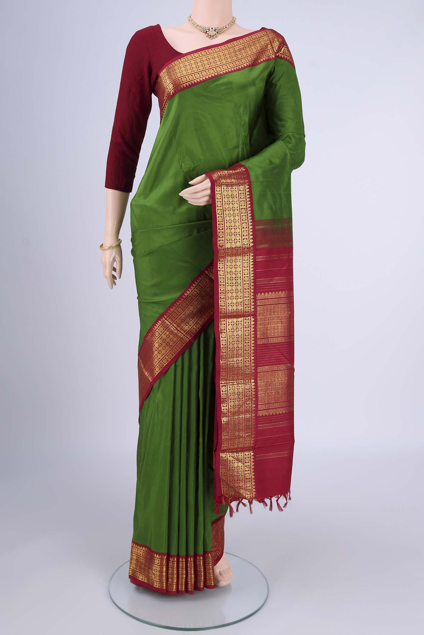 Green Kanjivaram Silk Saree with Plain Body and Zari Border.  displayed on a mannequin