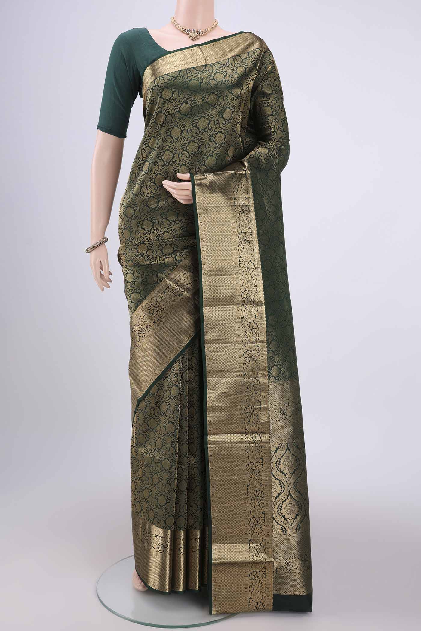 Bottle Green Soft Silk Saree with Zari Brocade on the body and Zari Border.  displayed on a mannequin