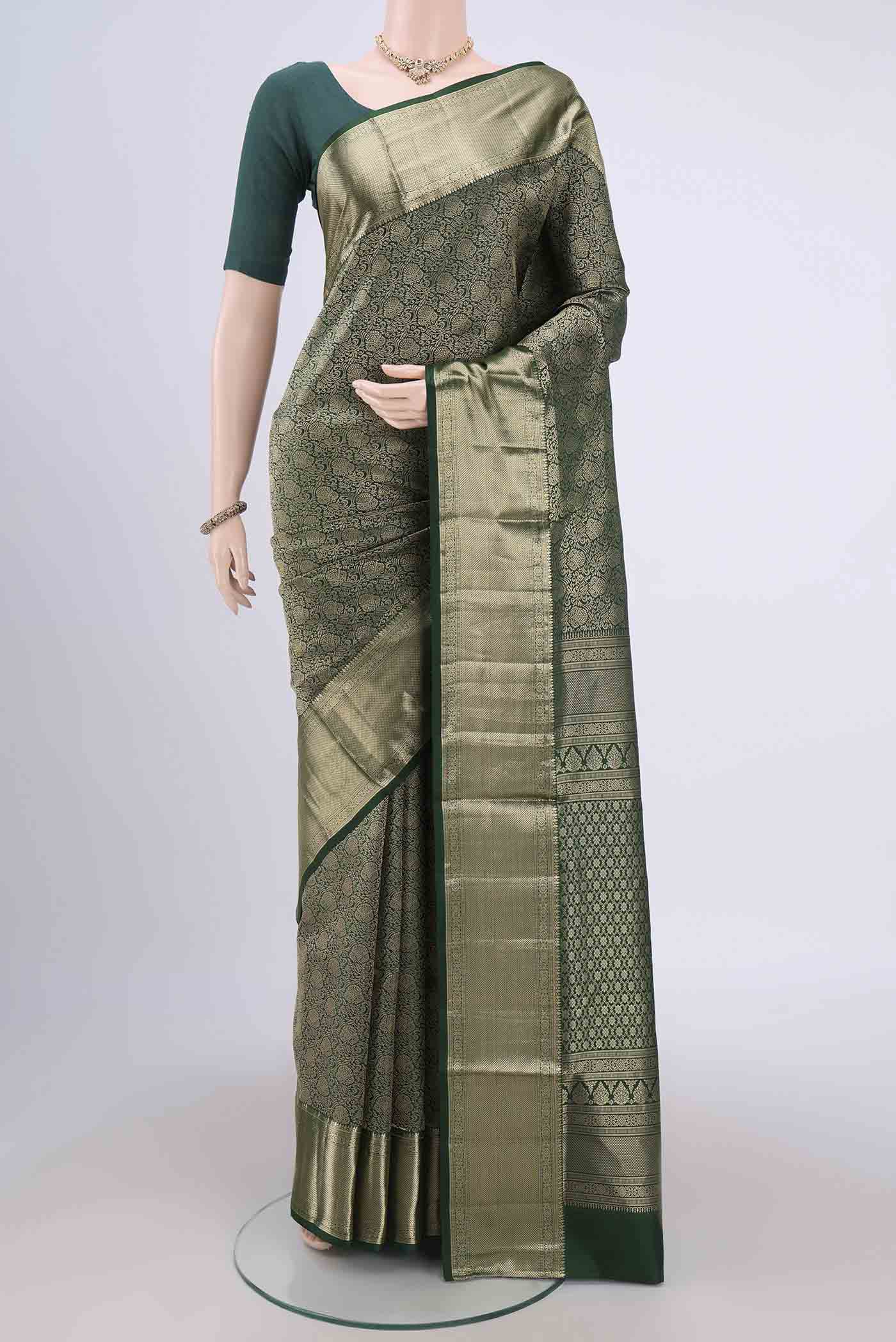 Bottle Green Soft Silk Saree with Zari Brocade on the body and Zari Border.  displayed on a mannequin