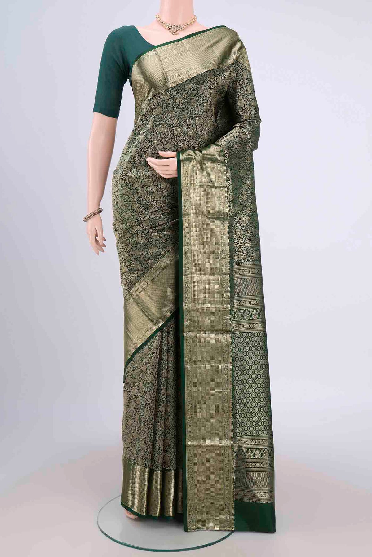 Bottle Green Soft Silk Saree with Zari Brocade on the body and Zari Border.  displayed on a mannequin