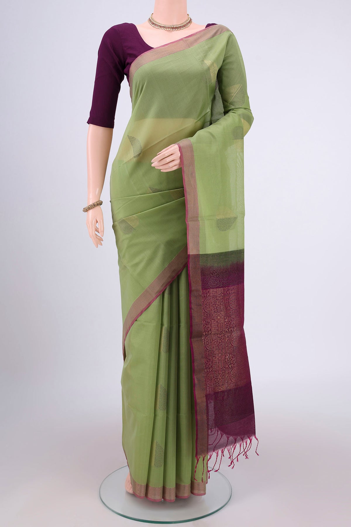 Light Green Silk Cotton Saree with Zari Butta on the body and Zari Border.  displayed on a mannequin