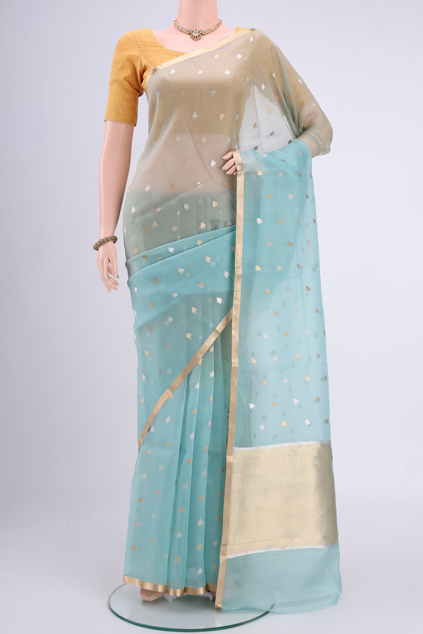 Sky Blue Organza Silk Saree with Zari Butta on the body and Zari Border.  displayed on a mannequin