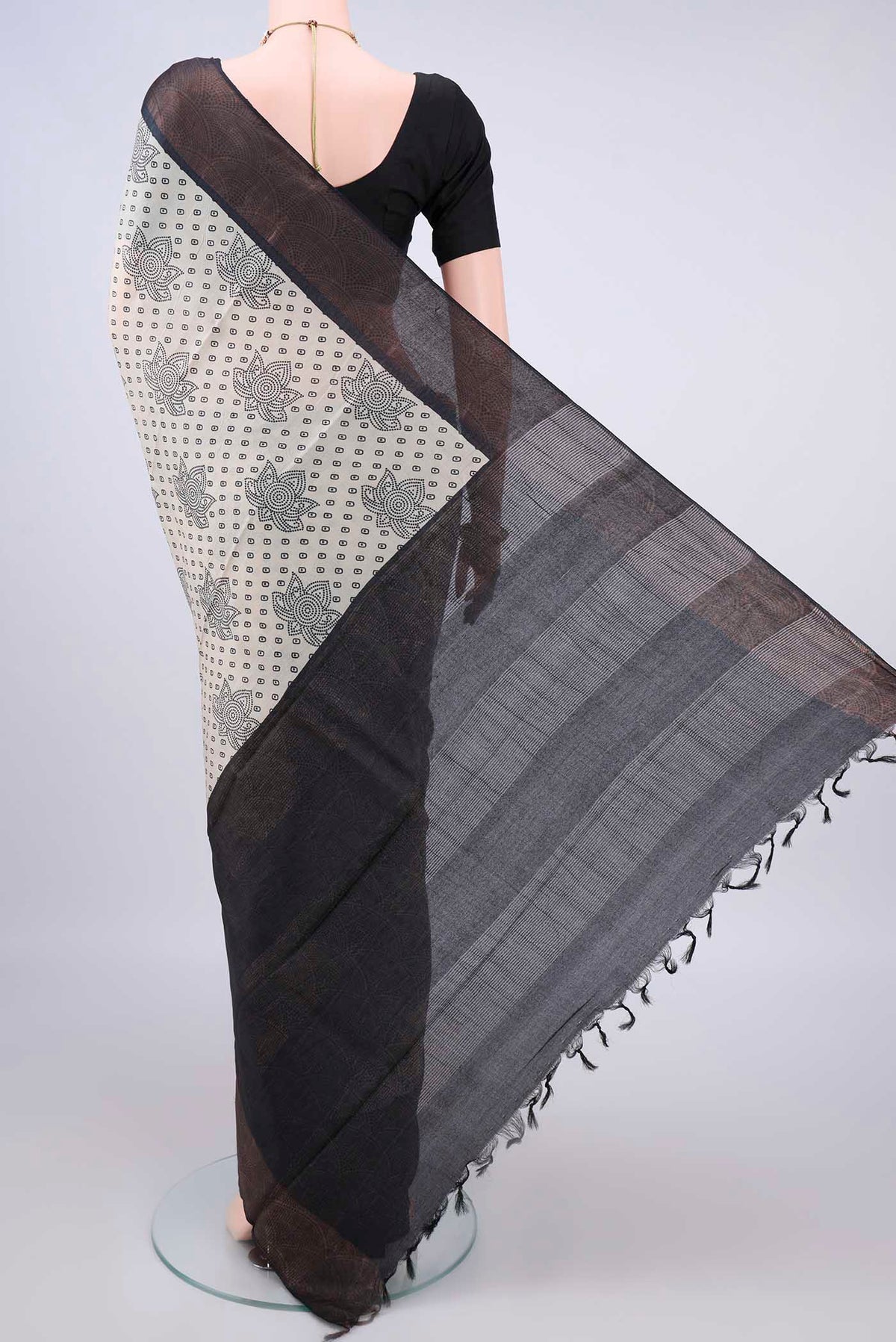 Flat view of Cream Tussar Saree with Printed design on the body and Zari Border. 