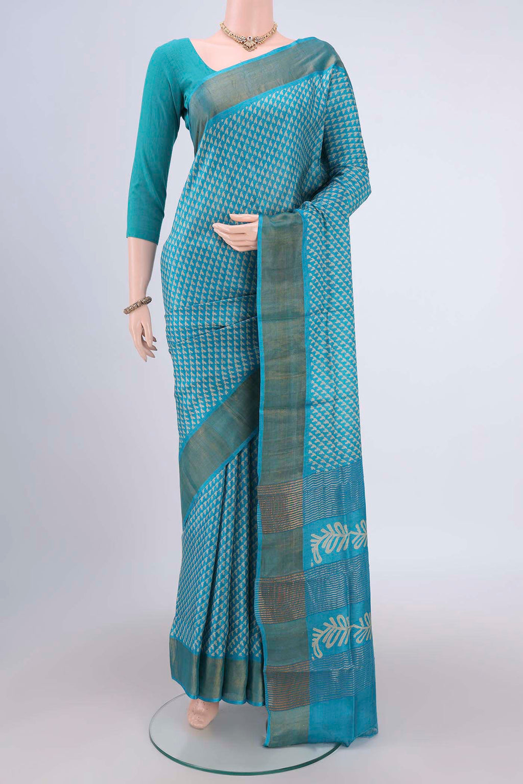Turquoise Tussar Silk Saree with Printed design on the body and Zari Border.  displayed on a mannequin