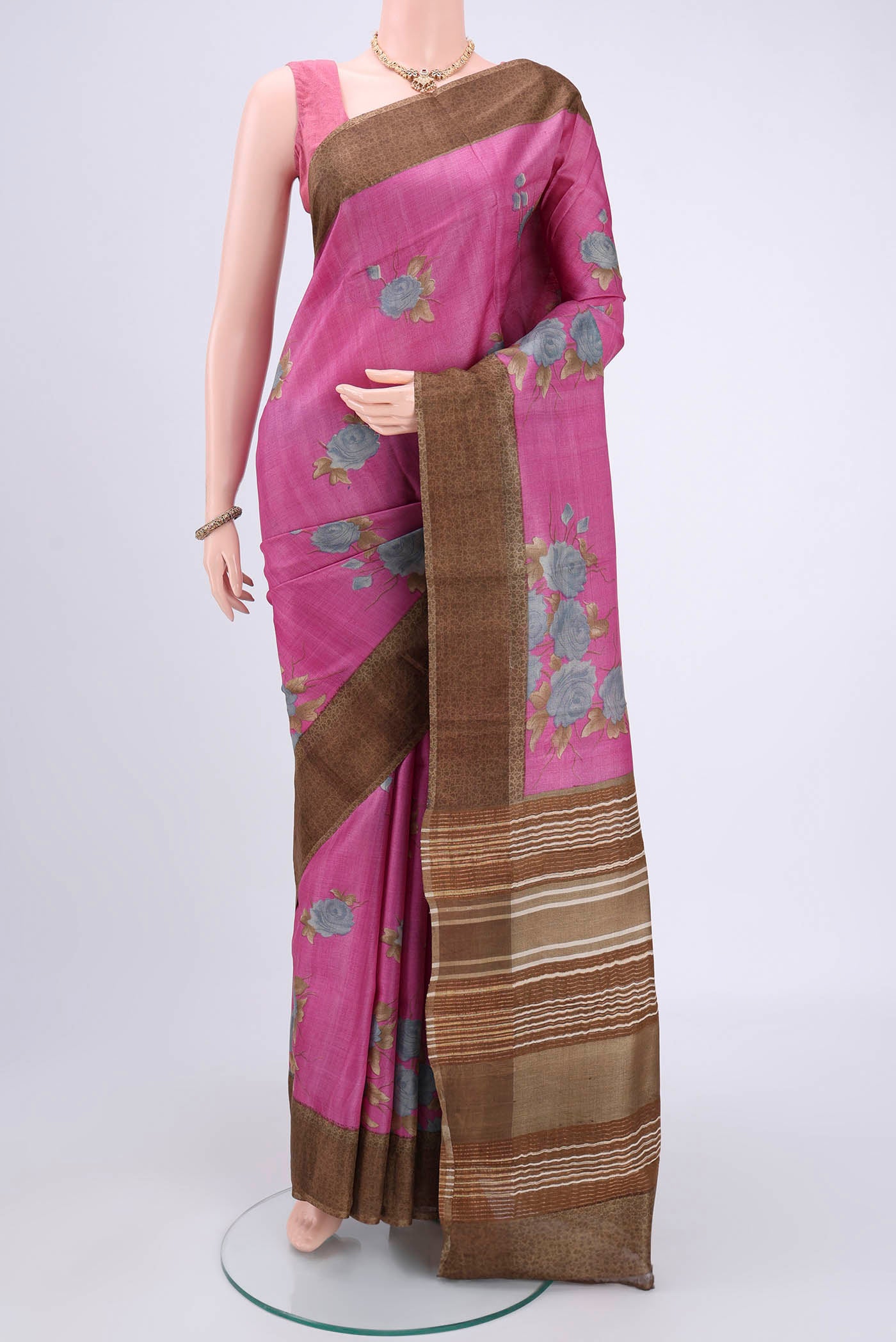 Pink Printed Silk Saree with Floral Print on the body and Zari Border.  displayed on a mannequin