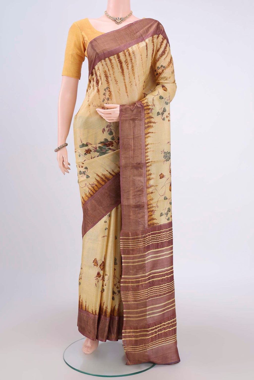 Cream Tussar Silk Saree with Printed design on the body and Zari Border.  displayed on a mannequin