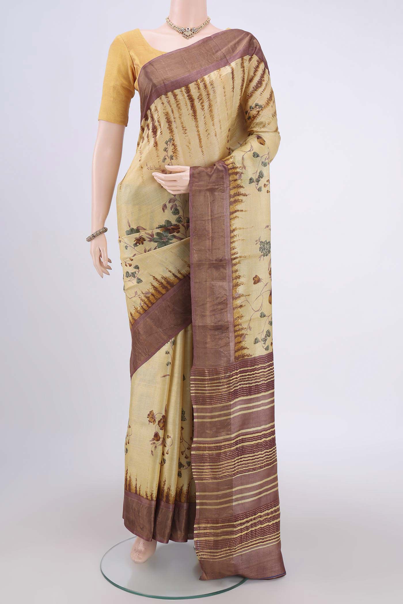 Cream Tussar Silk Saree with Printed design on the body and Zari Border.  displayed on a mannequin
