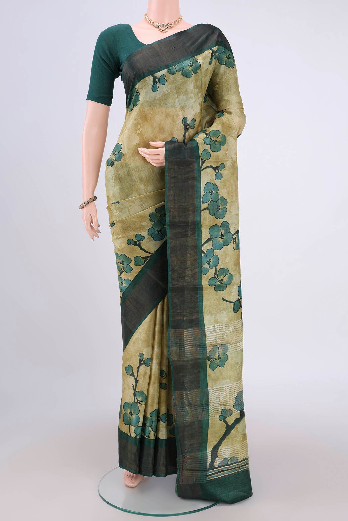 Light Green Tussar Silk Saree with Printed design on the body and Zari Border.  displayed on a mannequin