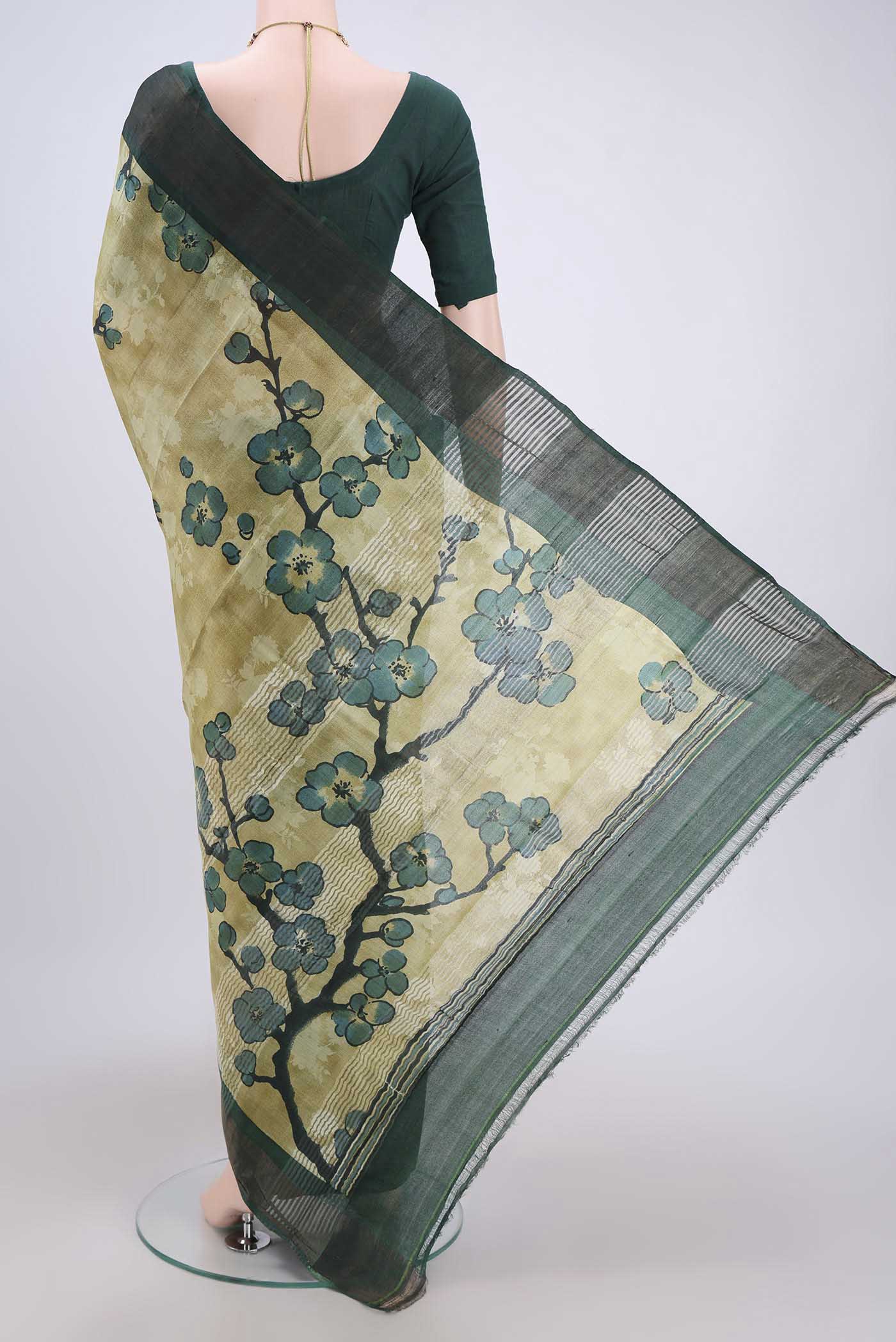 Flat view of Light Green Tussar Silk Saree with Printed design on the body and Zari Border. 