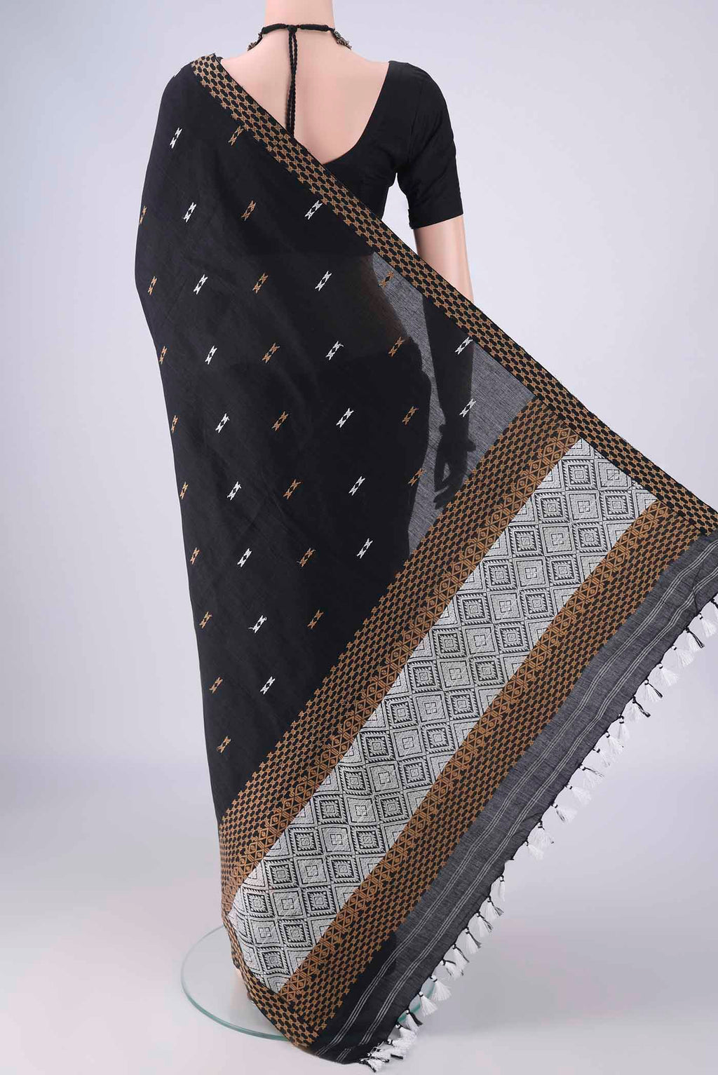 Flat view of Black Assam Cotton Saree with Thread Butta on the body and Thread Border. 