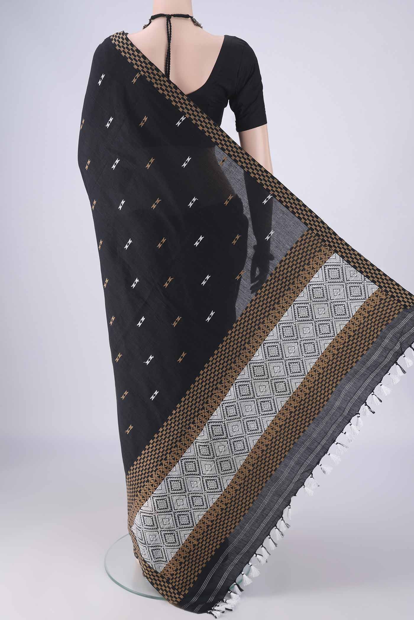 Flat view of Black Assam Cotton Saree with Thread Butta on the body and Thread Border. 