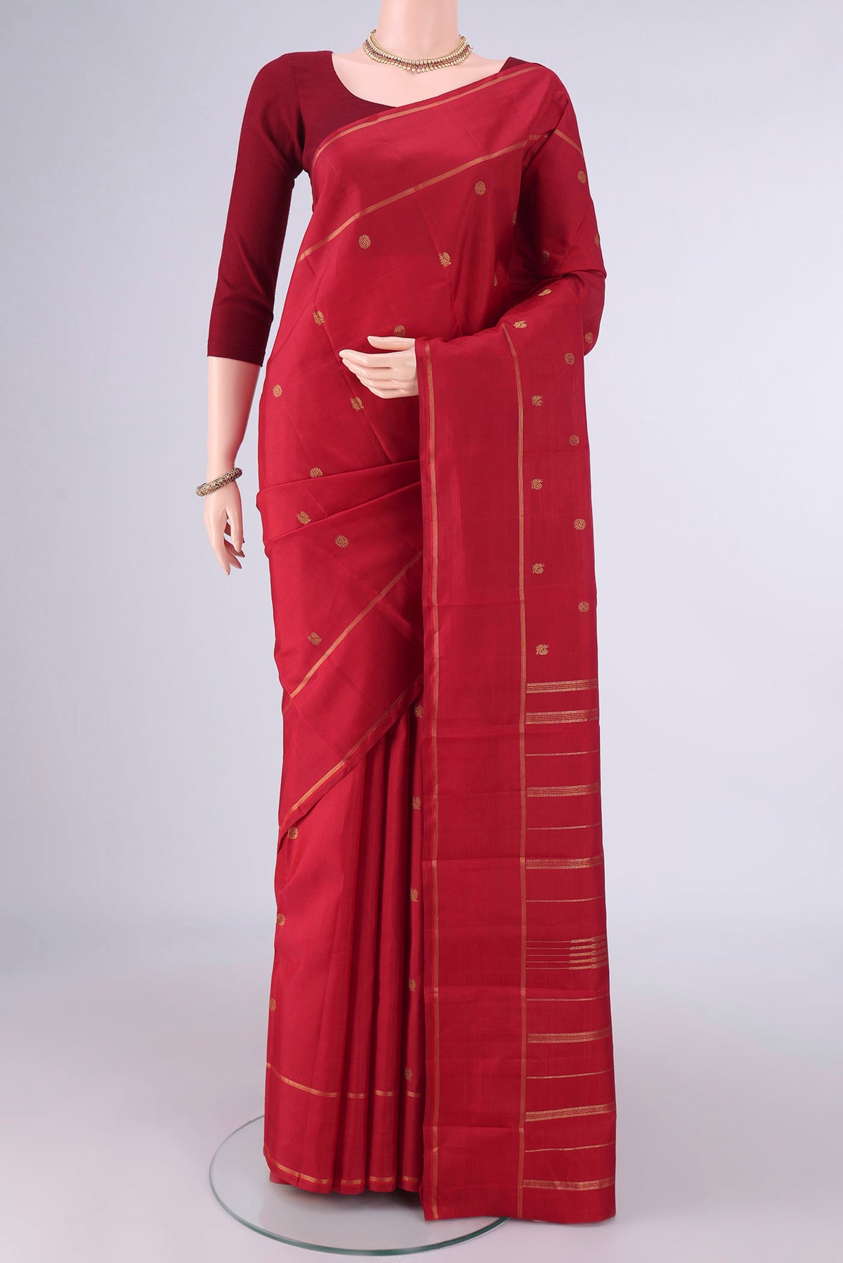 Pure Silk Red Kanjivaram Saree with Zari Butta on the body and Zari Border.  displayed on a mannequin