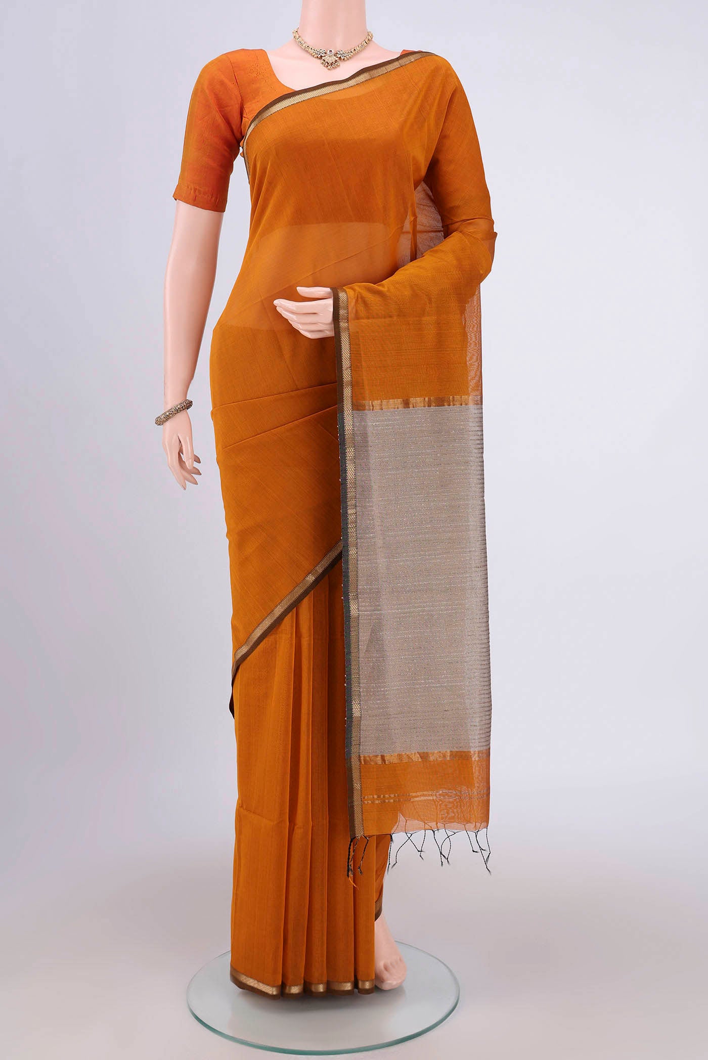 Mustard Maheshwari Silk Cotton Saree with Plain Body and Zari Border.  displayed on a mannequin
