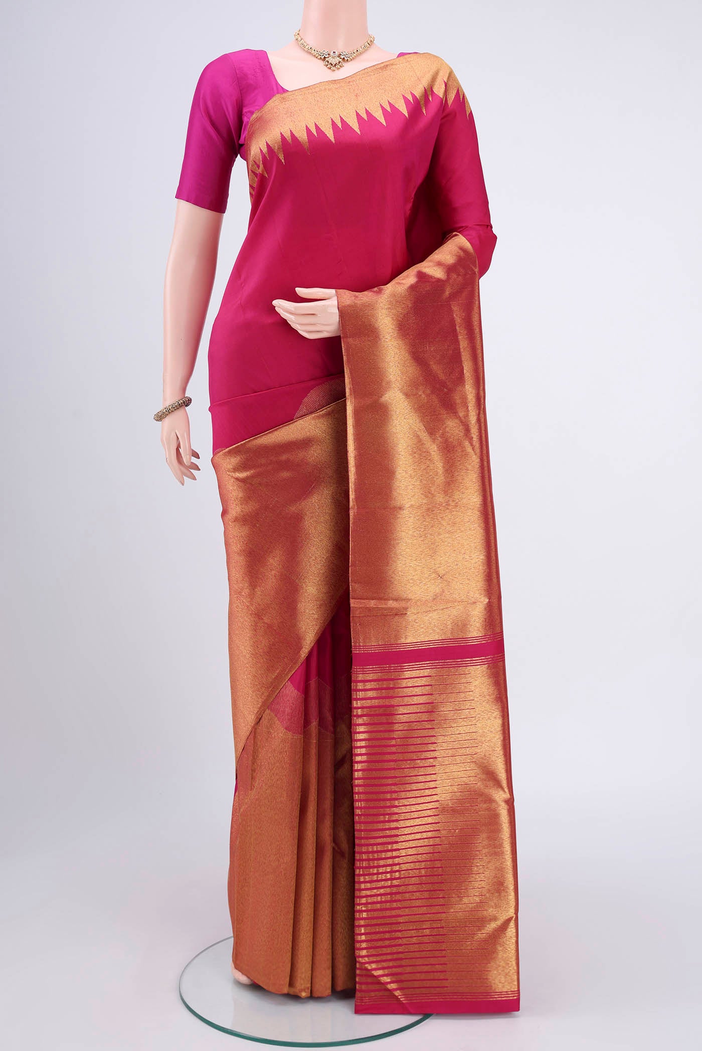 Rani Pink Kanjivaram Silk Saree with Plain Body and Rising Temple Border.  displayed on a mannequin