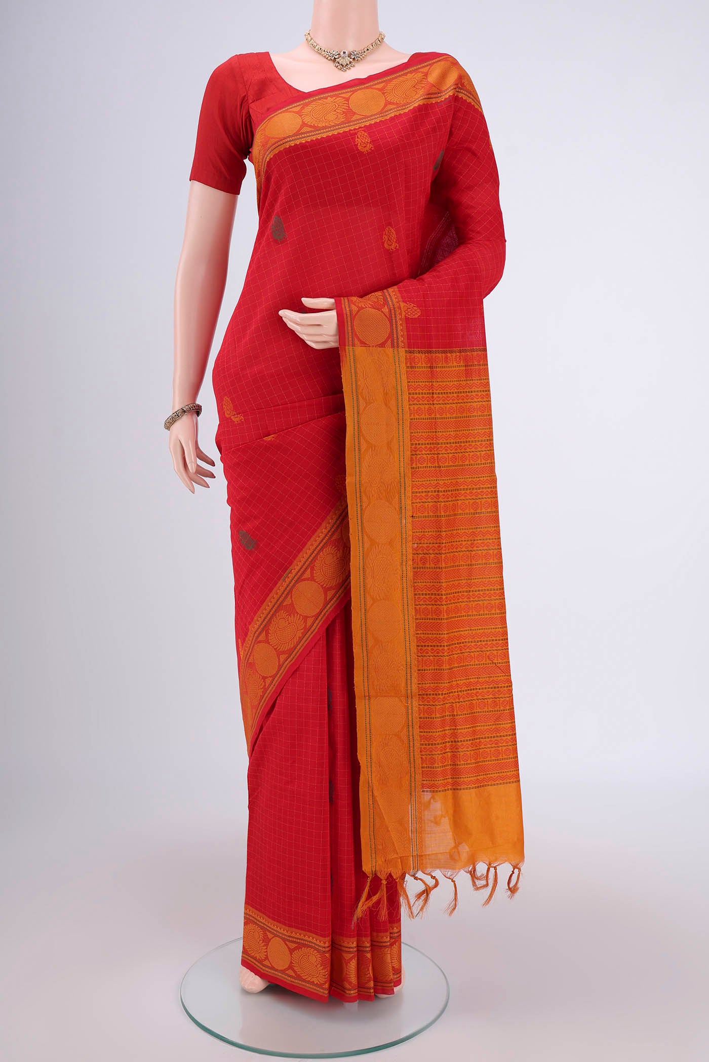 Red Blended Poly Cotton Saree with Zari Butta on the body and Zari Border.  displayed on a mannequin