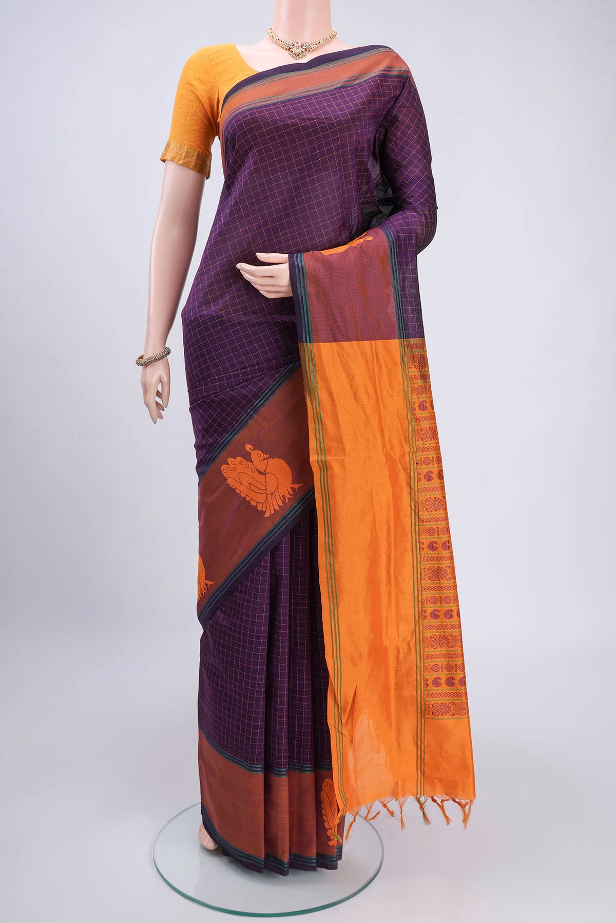 Purple Blended Poly Cotton Saree with Checked design on the body and Thread Border.  displayed on a mannequin