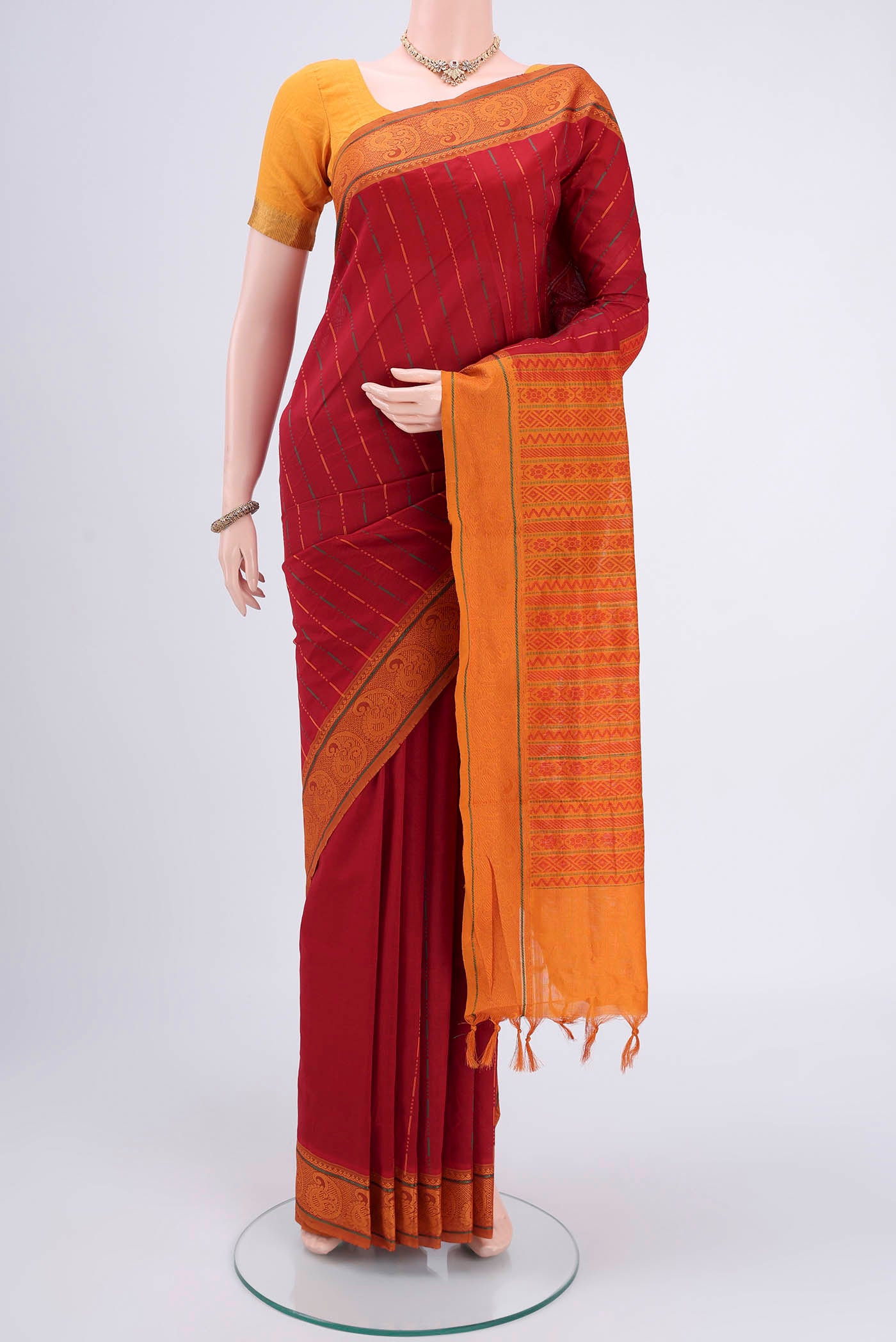 Red Blended Poly Cotton Saree with Stripes on the body and Thread Border.  displayed on a mannequin