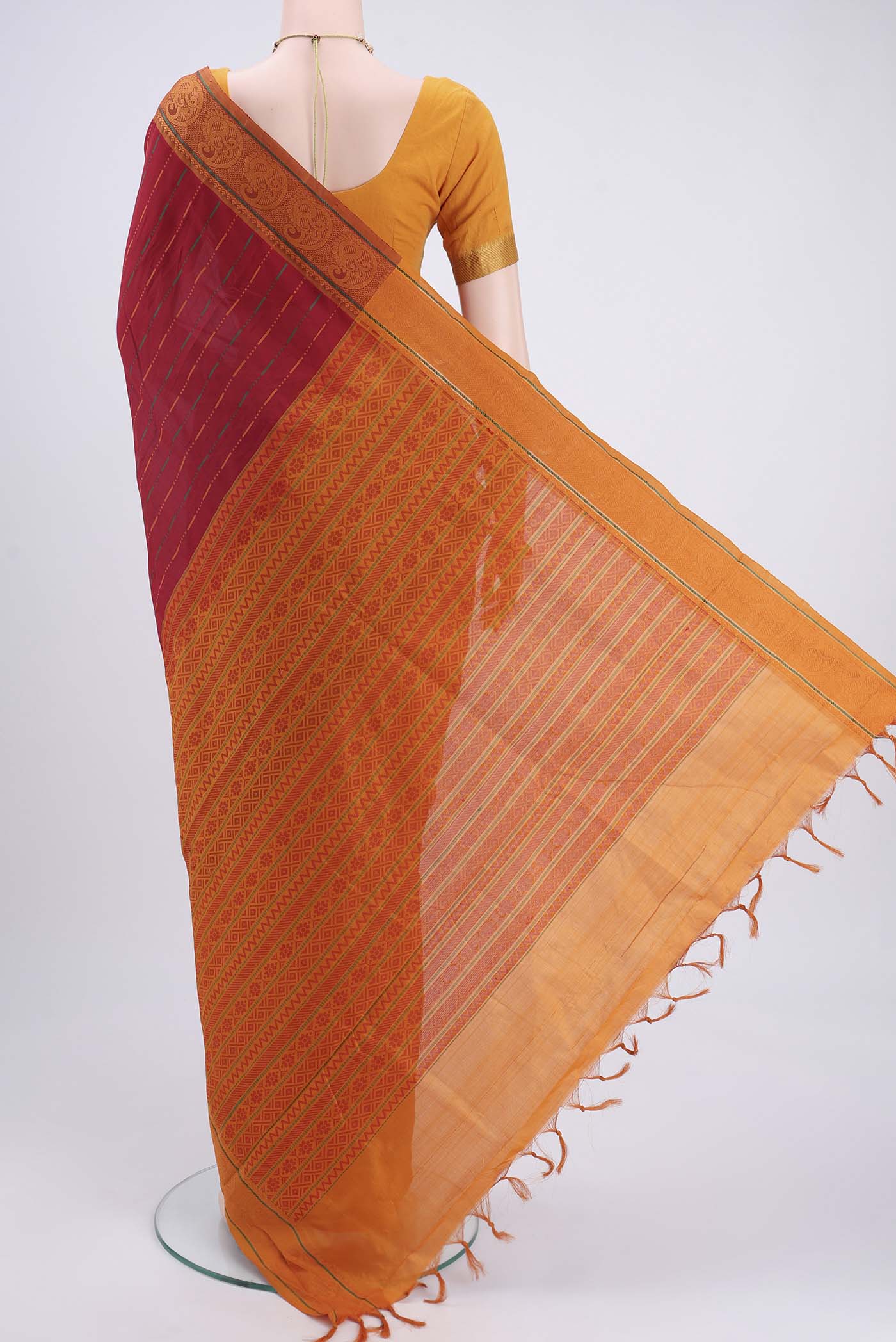 Flat view of Red Blended Poly Cotton Saree with Stripes on the body and Thread Border. 