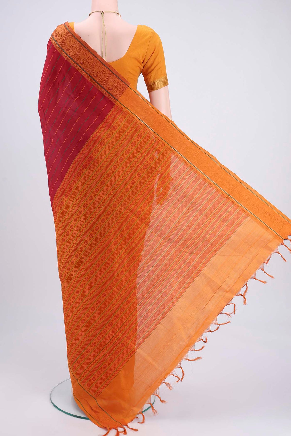 Flat view of Red Blended Poly Cotton Saree with Stripes on the body and Thread Border. 