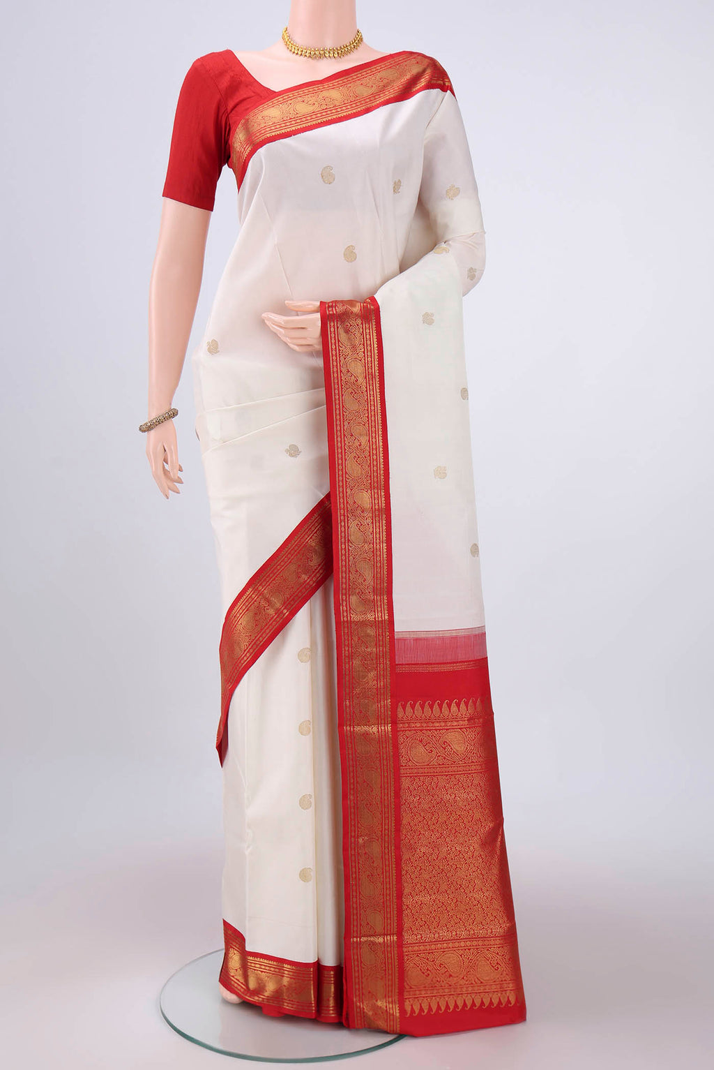 White Kanjivaram Saree with Zari Butta on the body and Zari Border.  displayed on a mannequin