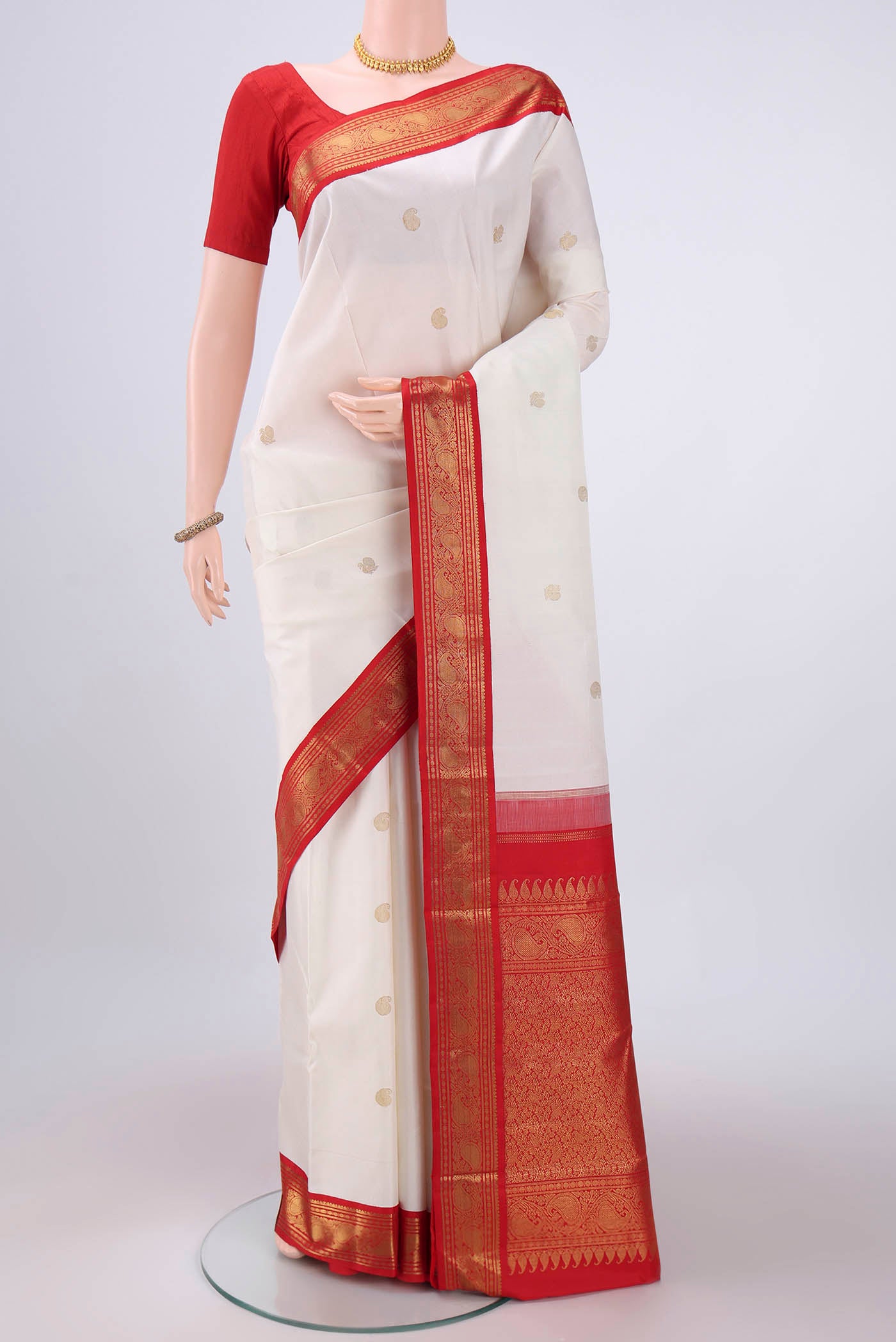 White Kanjivaram Saree with Zari Butta on the body and Zari Border.  displayed on a mannequin