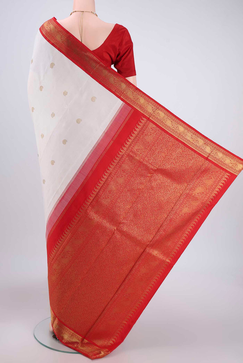 Flat view of White Kanjivaram Saree with Zari Butta on the body and Zari Border. 