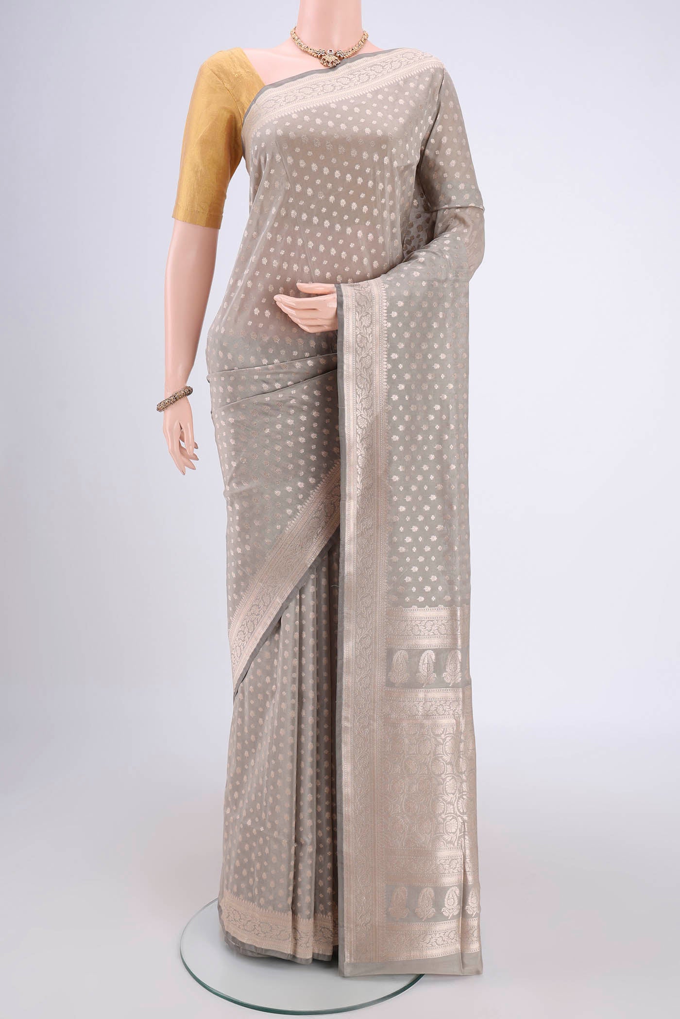 Grey Banarasi Silk Saree with Zari Butta on the body and Zari Border.  displayed on a mannequin