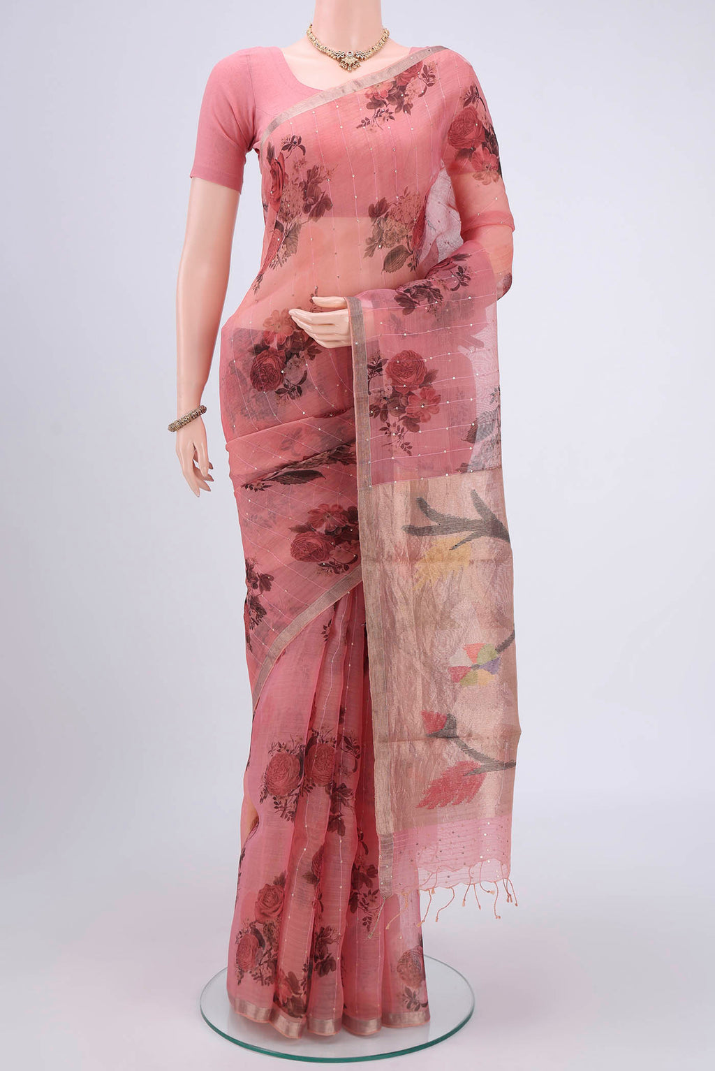 Coral Organza Silk Saree with Printed design on the body and Zari Border.  displayed on a mannequin