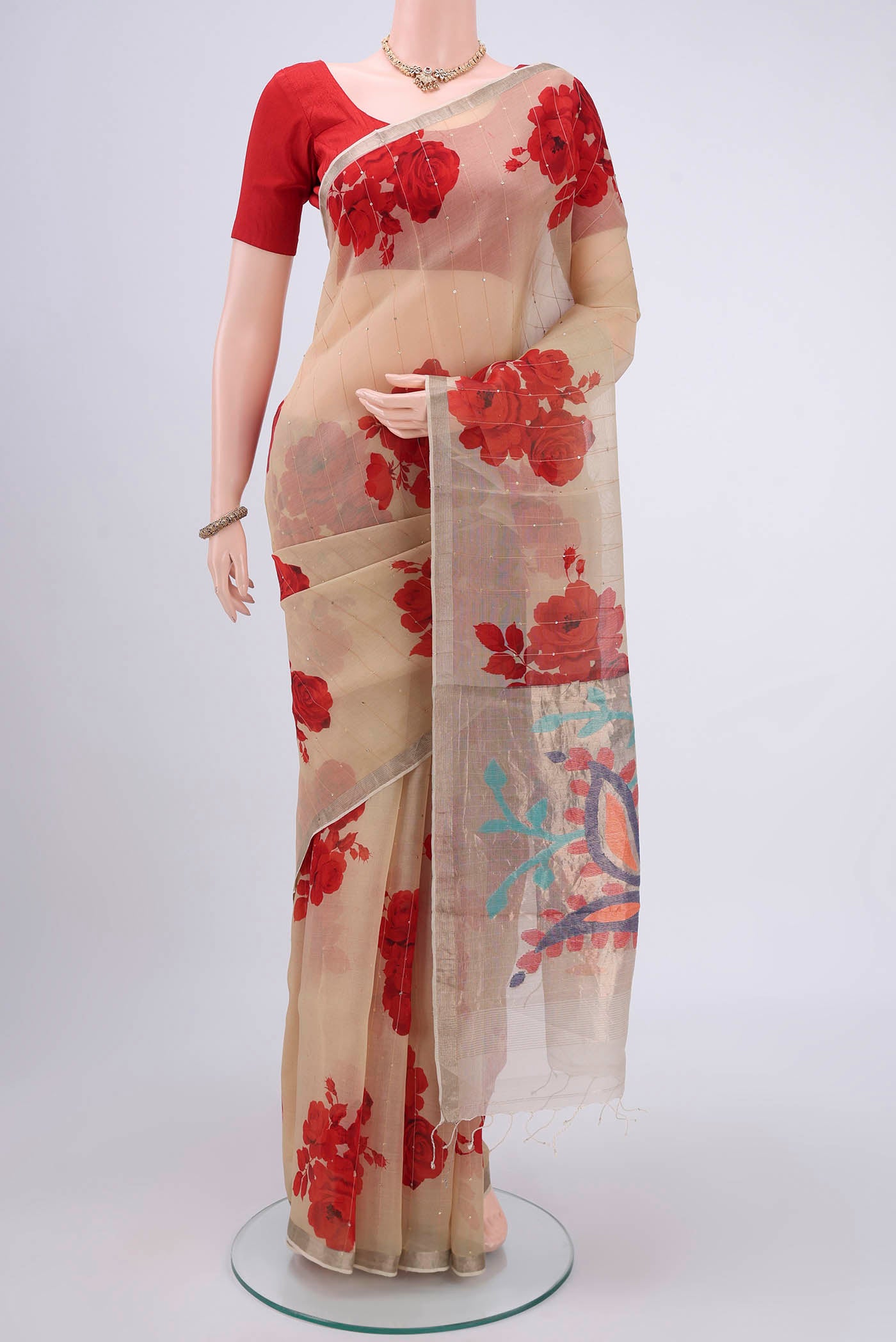 Beige Organza Silk Saree with Printed design on the body and Zari Border.  displayed on a mannequin