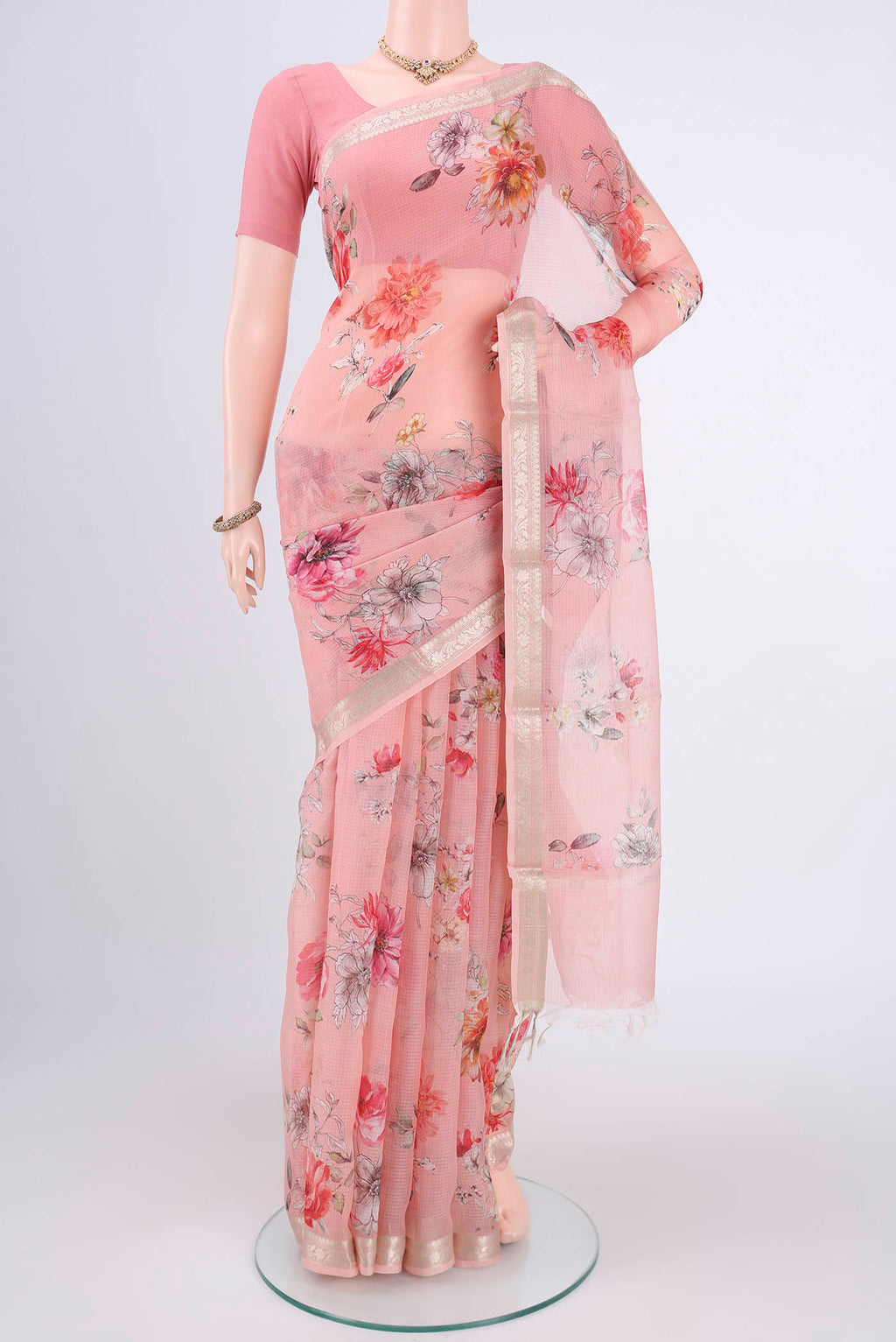 Peach Kota Silk Saree with Printed design on the body and Zari Border.  displayed on a mannequin