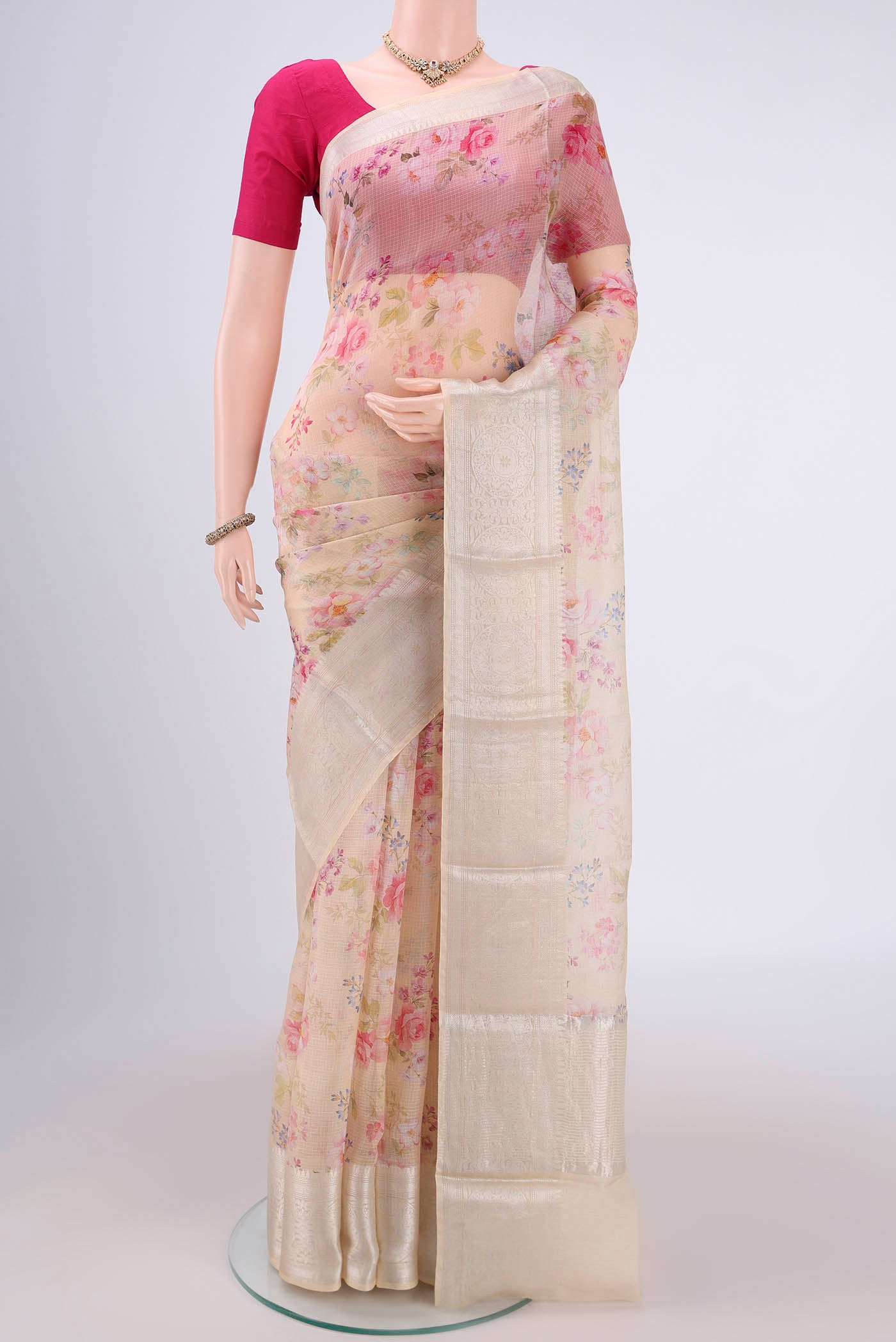 Cream Kota Silk Saree with Floral Print on the body and Zari Border.  displayed on a mannequin