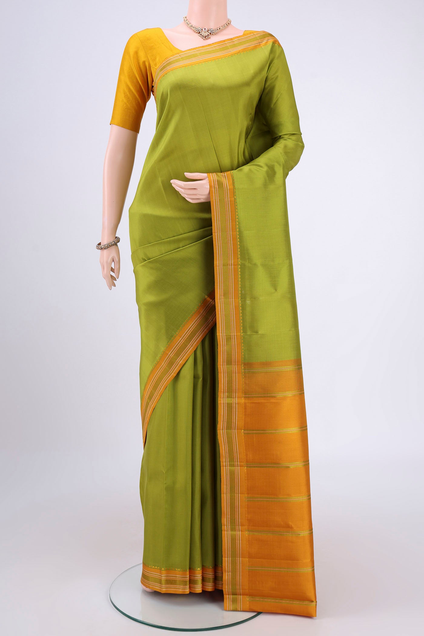 Light Green Kanjivaram Silk Saree with Plain Body and Thread Border.  displayed on a mannequin