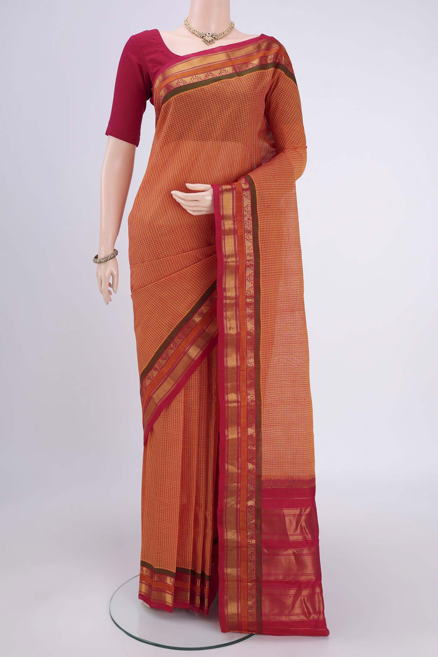 Brick Orange Dual Tone Gadwal Silk Cotton Saree with Checked design on the body and Silk Border.  displayed on a mannequin