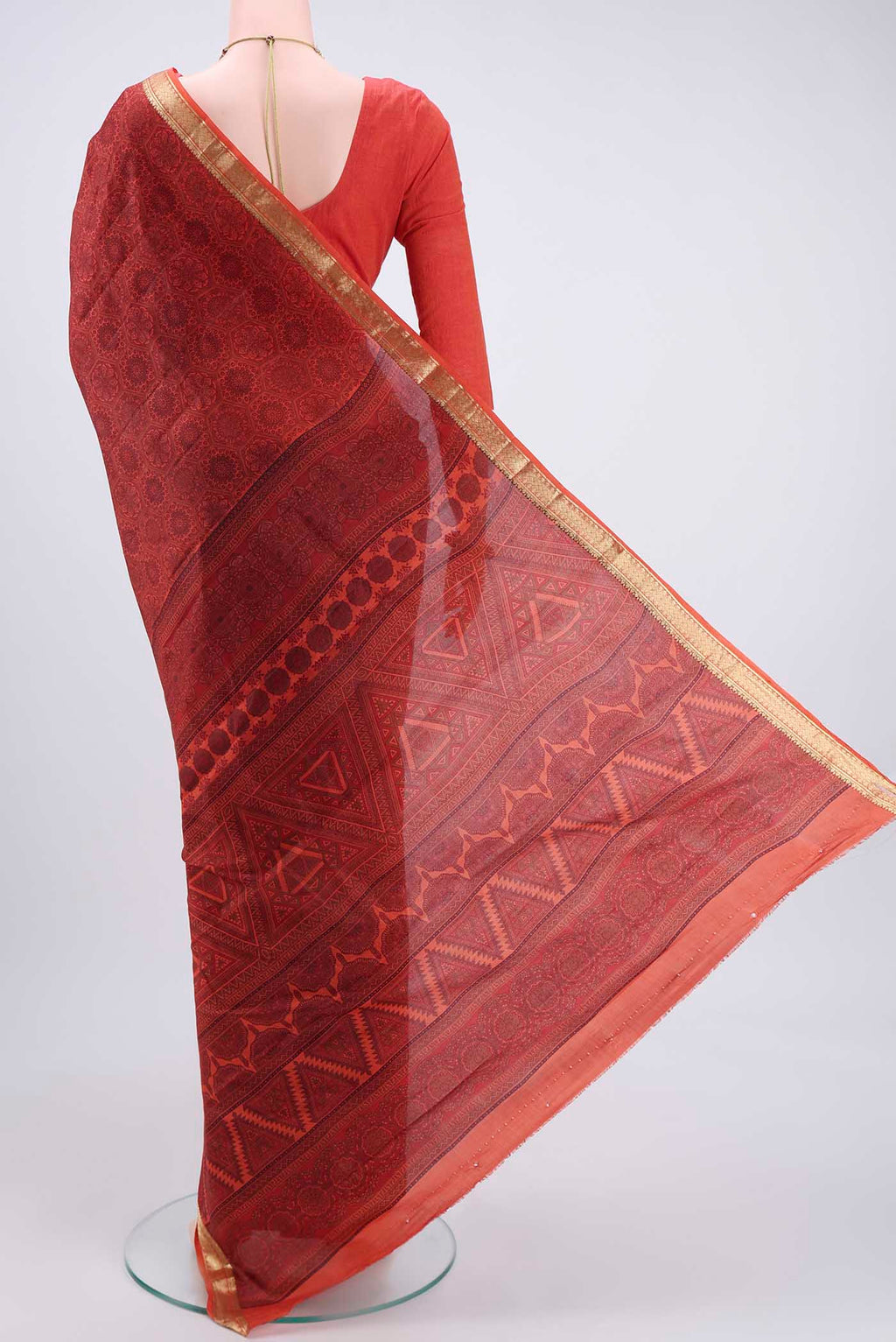 Flat view of Brick Orange Printed Silk Saree with Printed design on the body and Zari Border. 