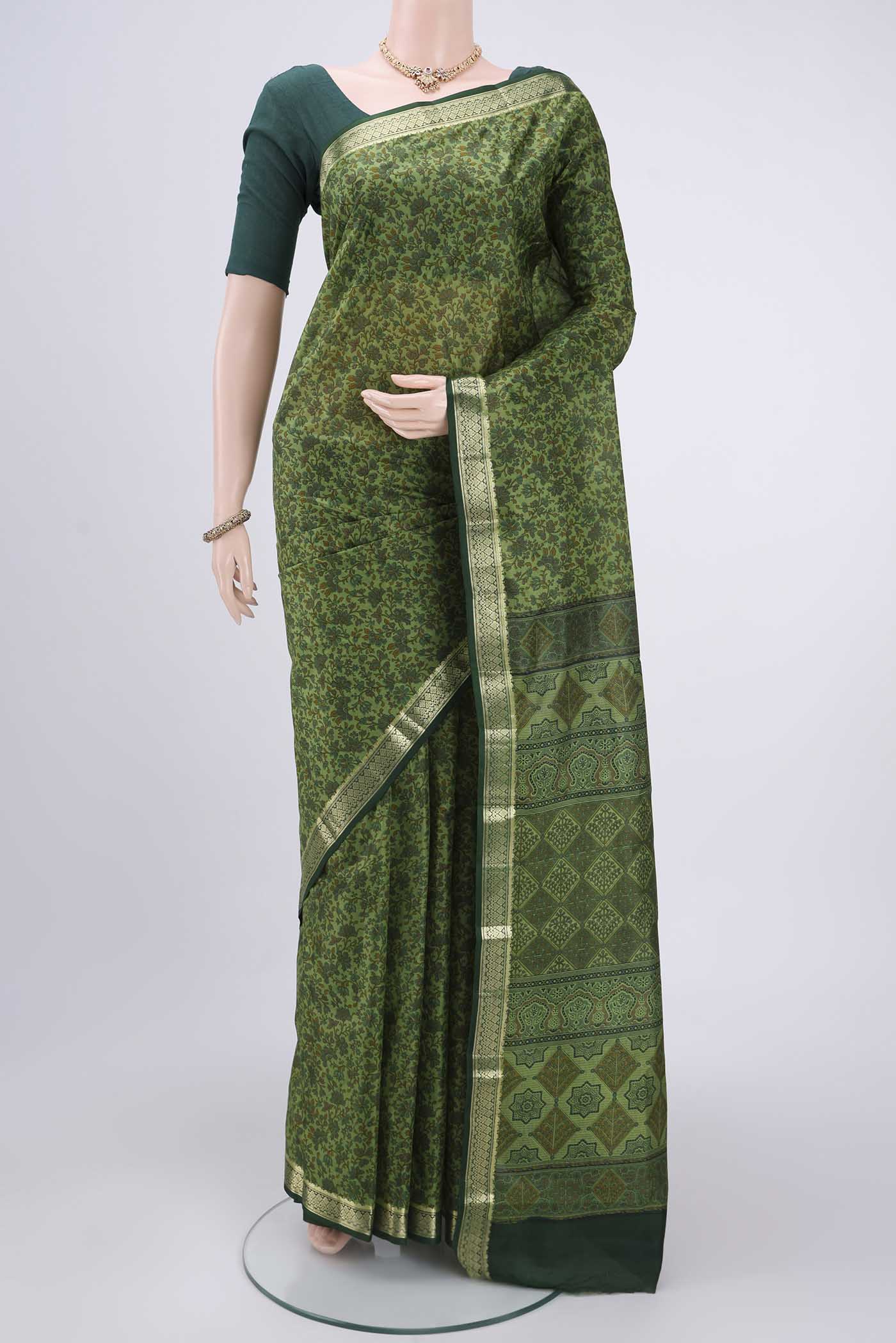 Light Green Printed Silk Saree with Printed design on the body and Zari Border.  displayed on a mannequin