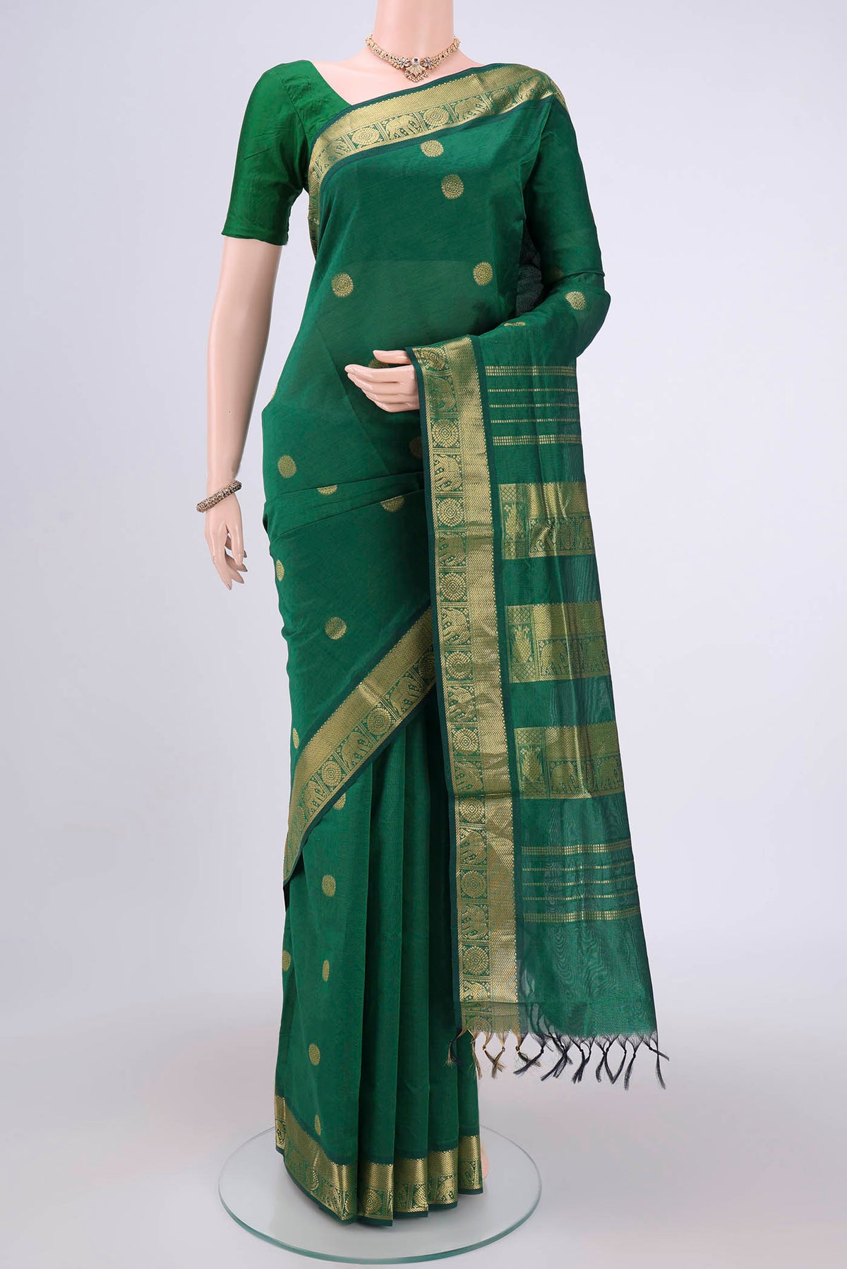 Bottle Green Blended Poly Cotton Saree with Zari Butta on the body and Zari Border.  displayed on a mannequin