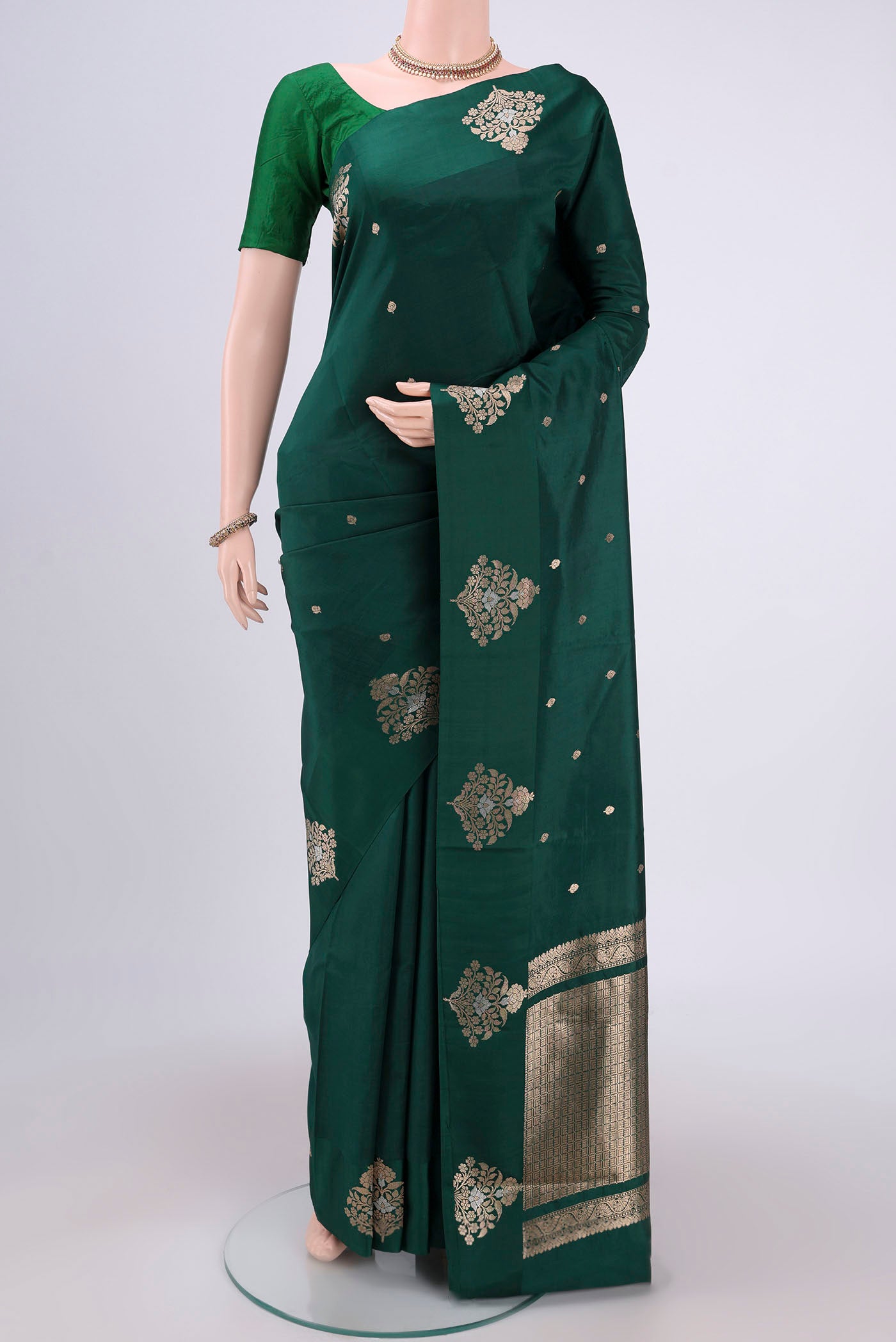 Green Banarasi Katan Silk Saree with Zari Butta on the body and Zari Border.  displayed on a mannequin